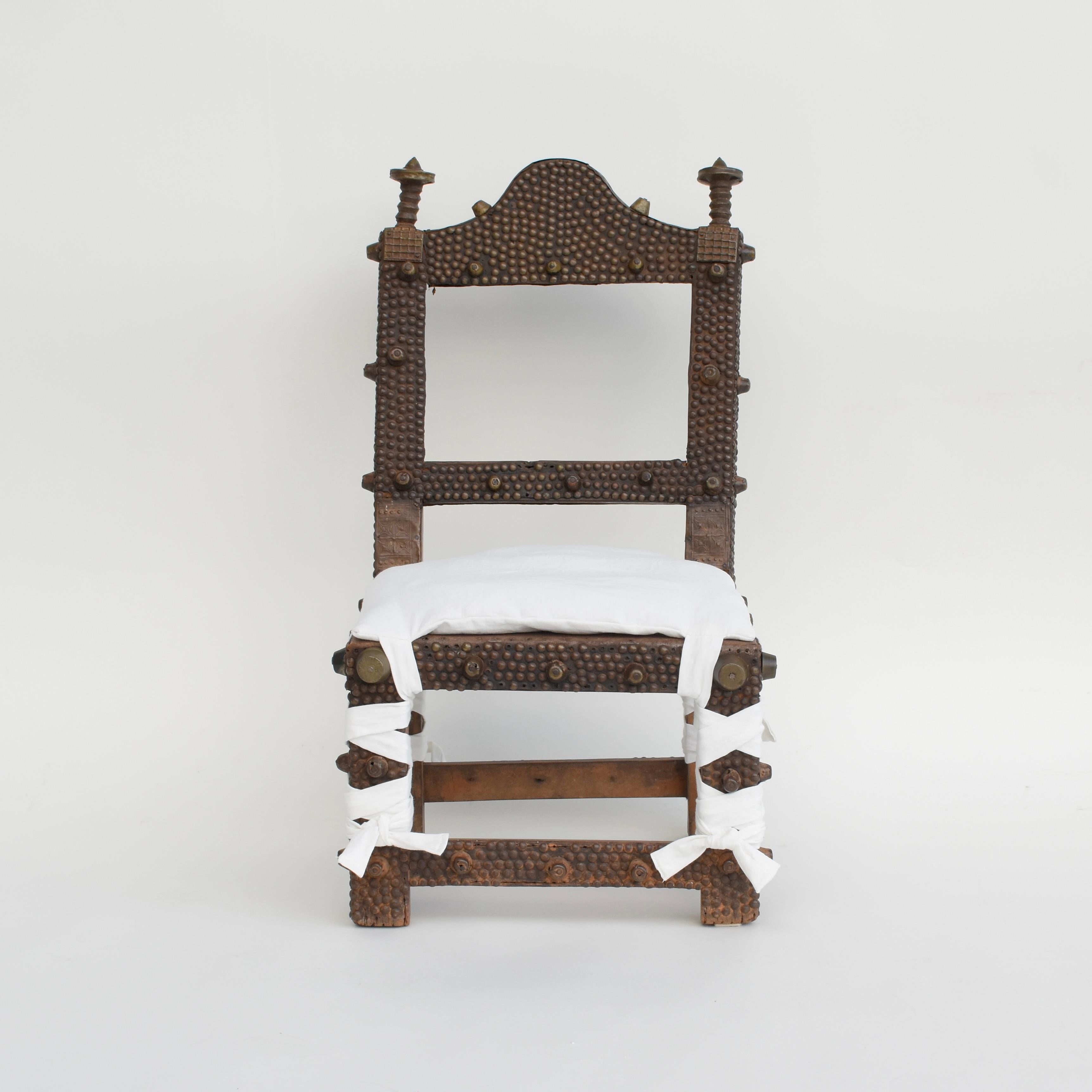 Une chaise royale dans la société Asante C'est un signe de pouvoir et de prestige utilisé exclusivement par les chefs. La chaise est composée d'un cadre en bois sculpté à la main, recouvert de clous et de punaises en laiton martelé et d'une assise