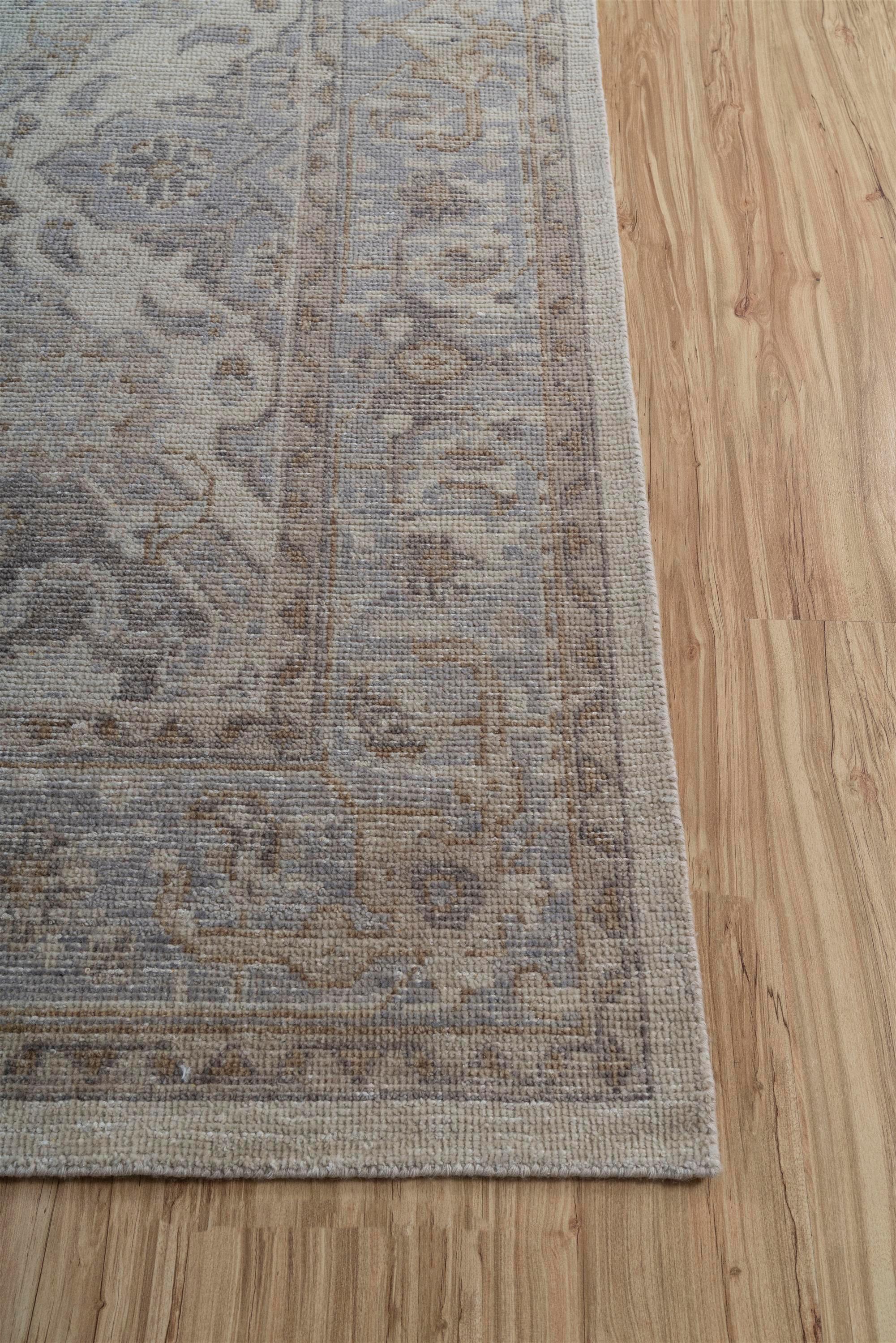 Introducing the exquisite hand-knotted rug , a masterpiece in wool craftsmanship. The rug boasts an enchanting blend of antique white as its soothing ground color, harmoniously bordered by ashwood hues. Meticulously knotted by skilled artisans, it