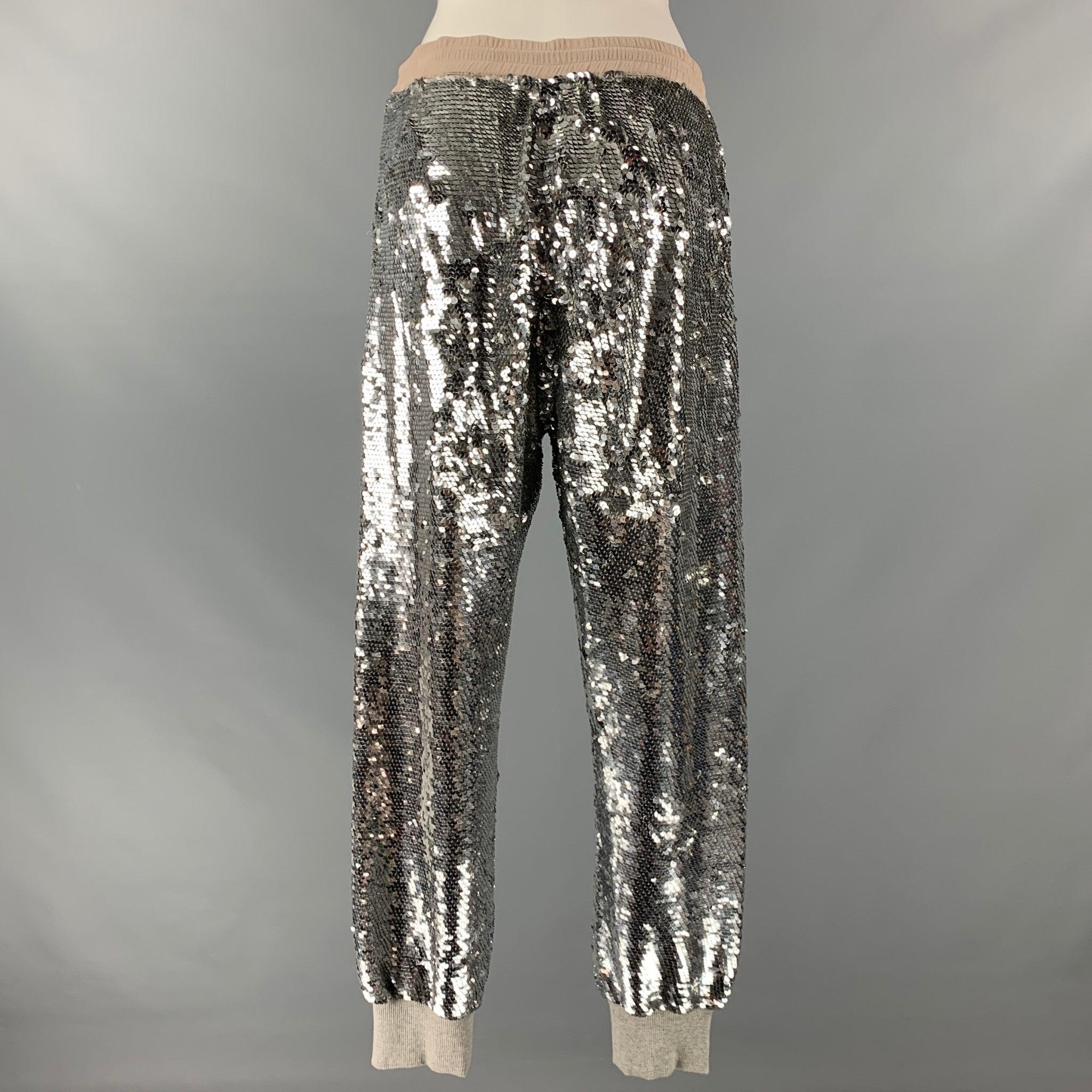 ASHISH pants comes in a silver sequined silk featuring a elastic waist, elastic cuffs, zipper pockets, and a drawstring detail. Embroidered by hand.Very Good Pre-Owned Condition. 

Marked:   M 

Measurements: 
  Waist: 29 inches Rise: 13 inches