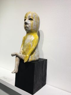 Ceramic figure on wood block: 'Varada mudra boy'