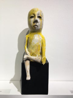 Ceramic figure on wood block: 'Varada mudra boy'