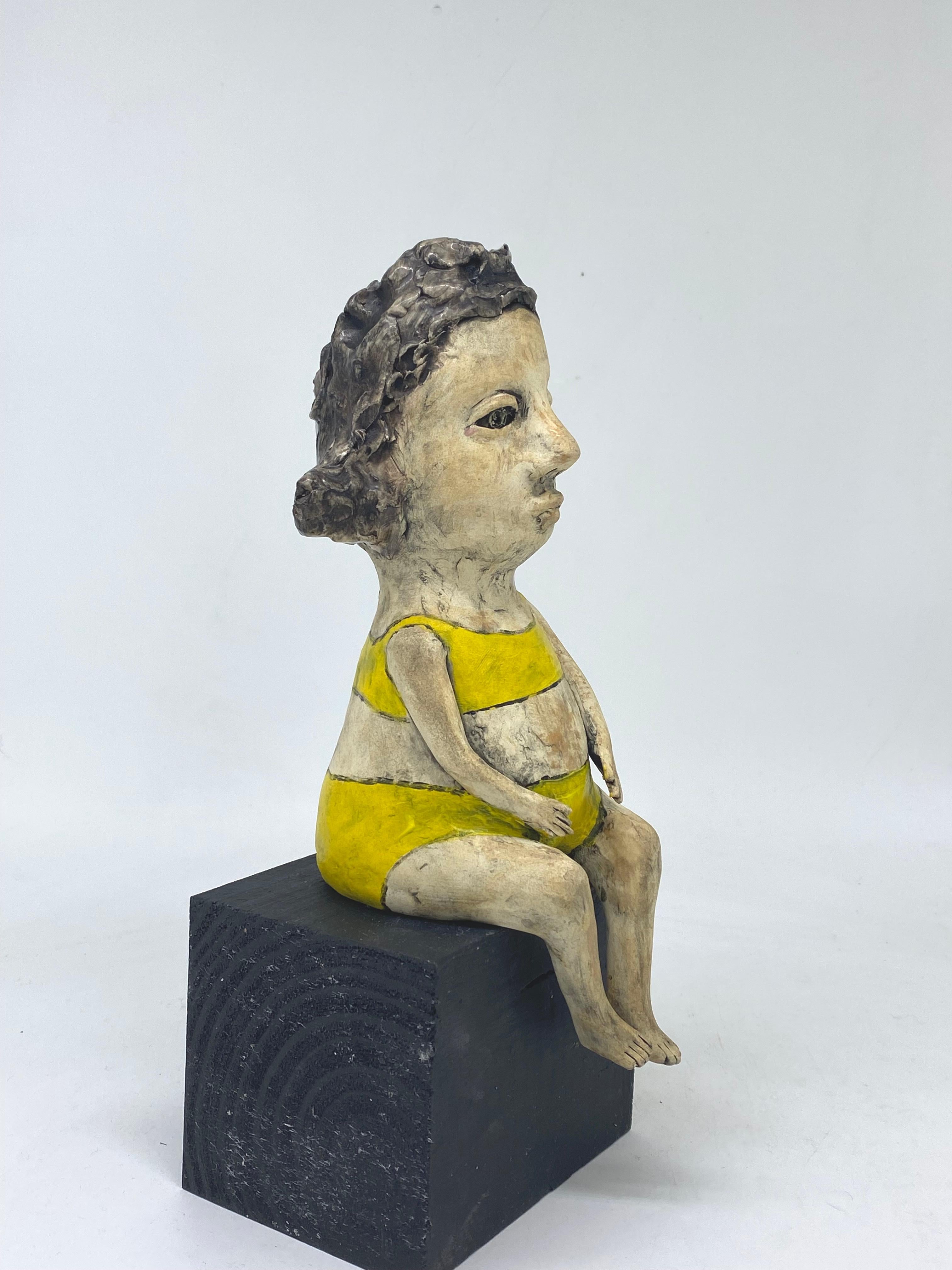 Ceramic figure seated on wood block: 'Cheer up' - Sculpture by Ashley Benton