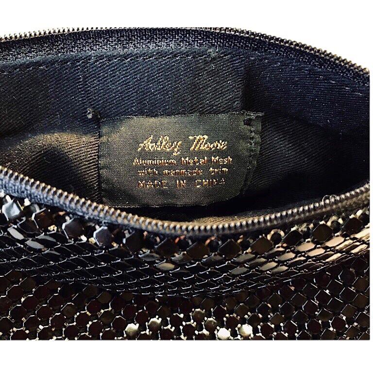This evening bag is made in China by Ashley Moore. The exterior is black enameled aluminum mesh. The interior fabric has a black satin finish. It has a gold metal link handle. The condition is excellent. 

MEASUREMENTS:
Purse: 7” wide x 5”