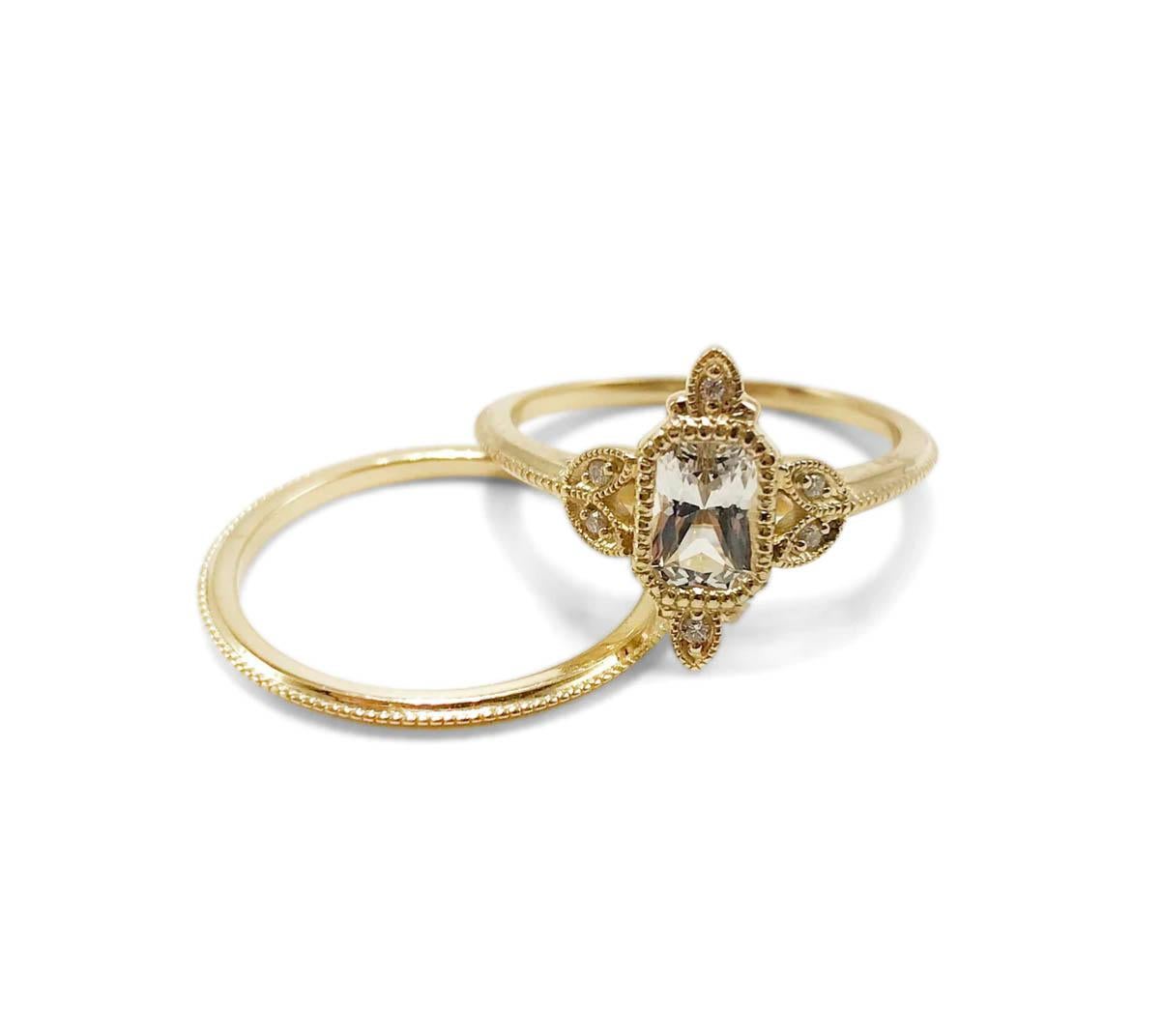 This 14K yellow gold band features detailed milgrain and metalwork surrounding an array of diamonds and a distinct emerald-cut center stone. Refined, elegant, and beautiful on the hand. 

Available to ship: 
- 14K Yellow Gold with an emerald cut