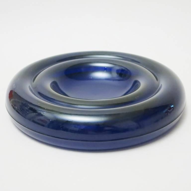 Ashtray Delos designed by Enzo Mari and produced by Danese Milano in 1980 and out of production. Heavy pressed blue glass. Signed.