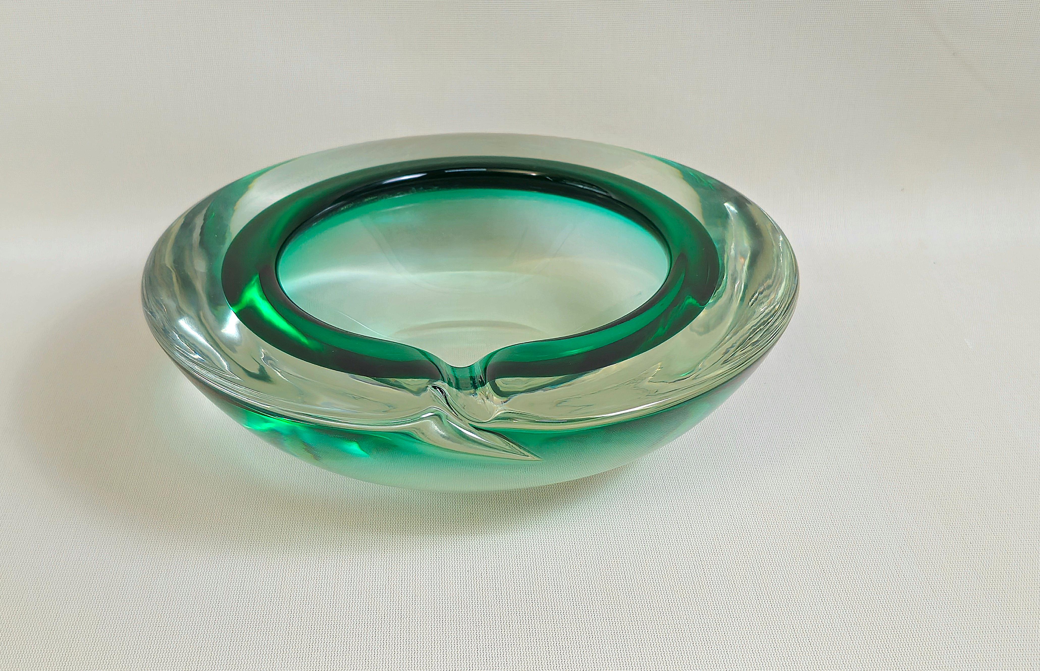 Imposanter kreisförmiger Aschenbecher aus sehr dickem Murano-Glas, in waldgrünen und transparenten Farbtönen. Ich hebe die hervorragende Qualität und Verarbeitung des Glases hervor. Hergestellt in Italien in den 60er Jahren.

Hinweis: Wir bemühen