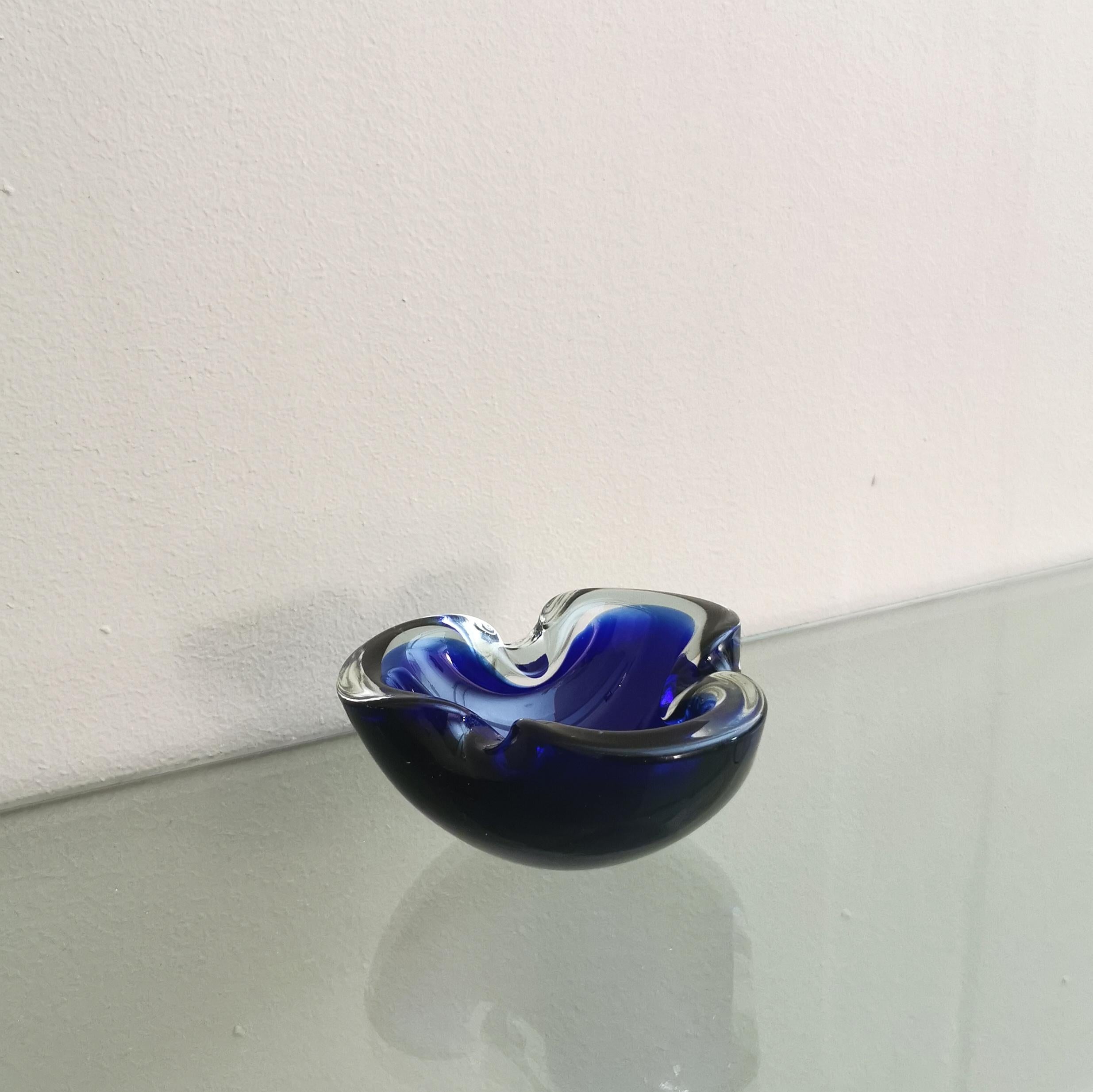Ashtray with sinuous lines produced in Italy in the 70s by the Italian designer Flavio Poli.
The ashtray was made of Murano glass, in shades of midnight blue and transparent with the famous 