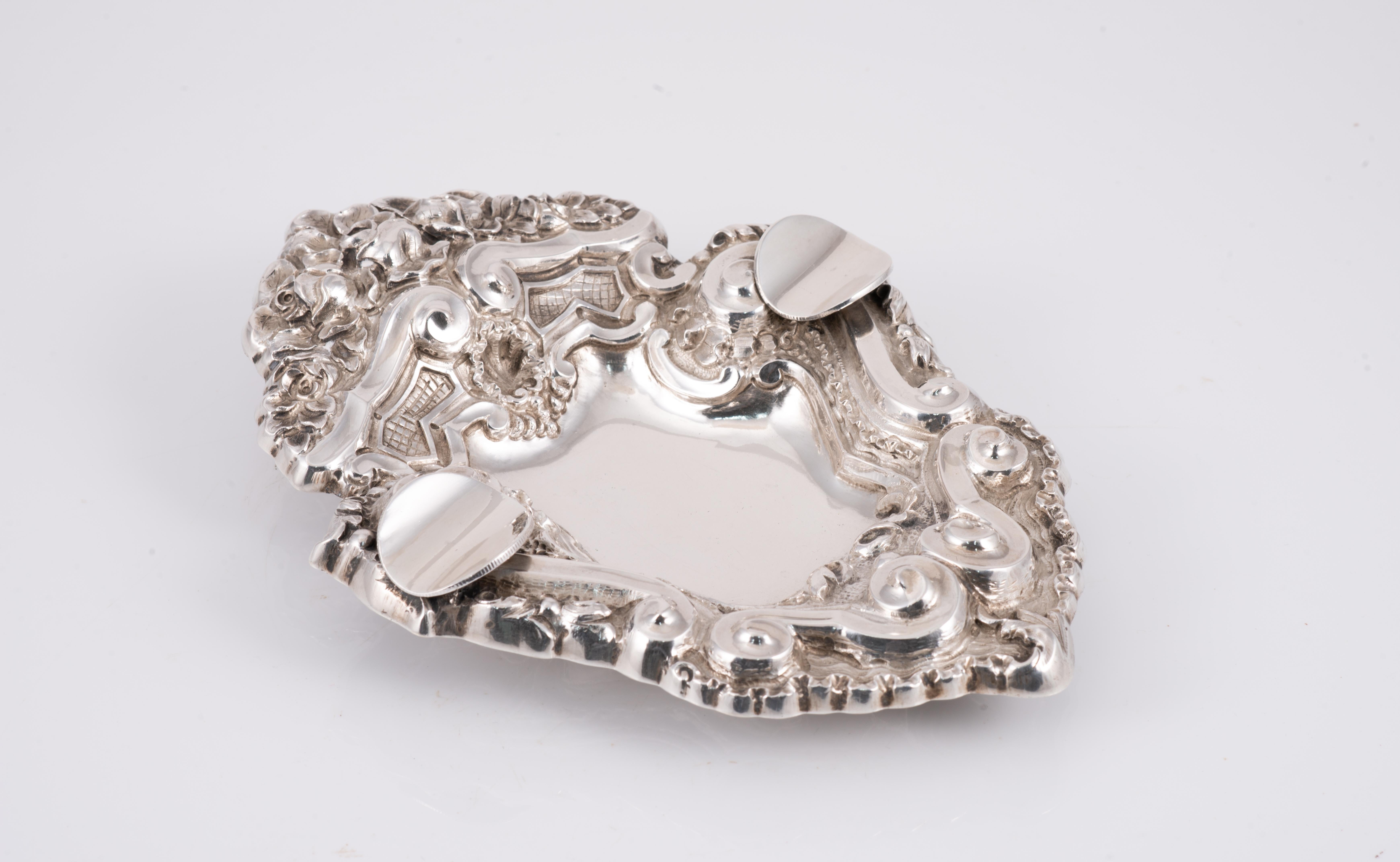 Ashtray. Silver (.833) in its colour. Porto, Portugal, 1938-1984. 
With contrast marks. 
Ashtray with two silver supports in its colour, decorated with a series of vegetal and architectural elements of Rococo influence (note the arched shape of the