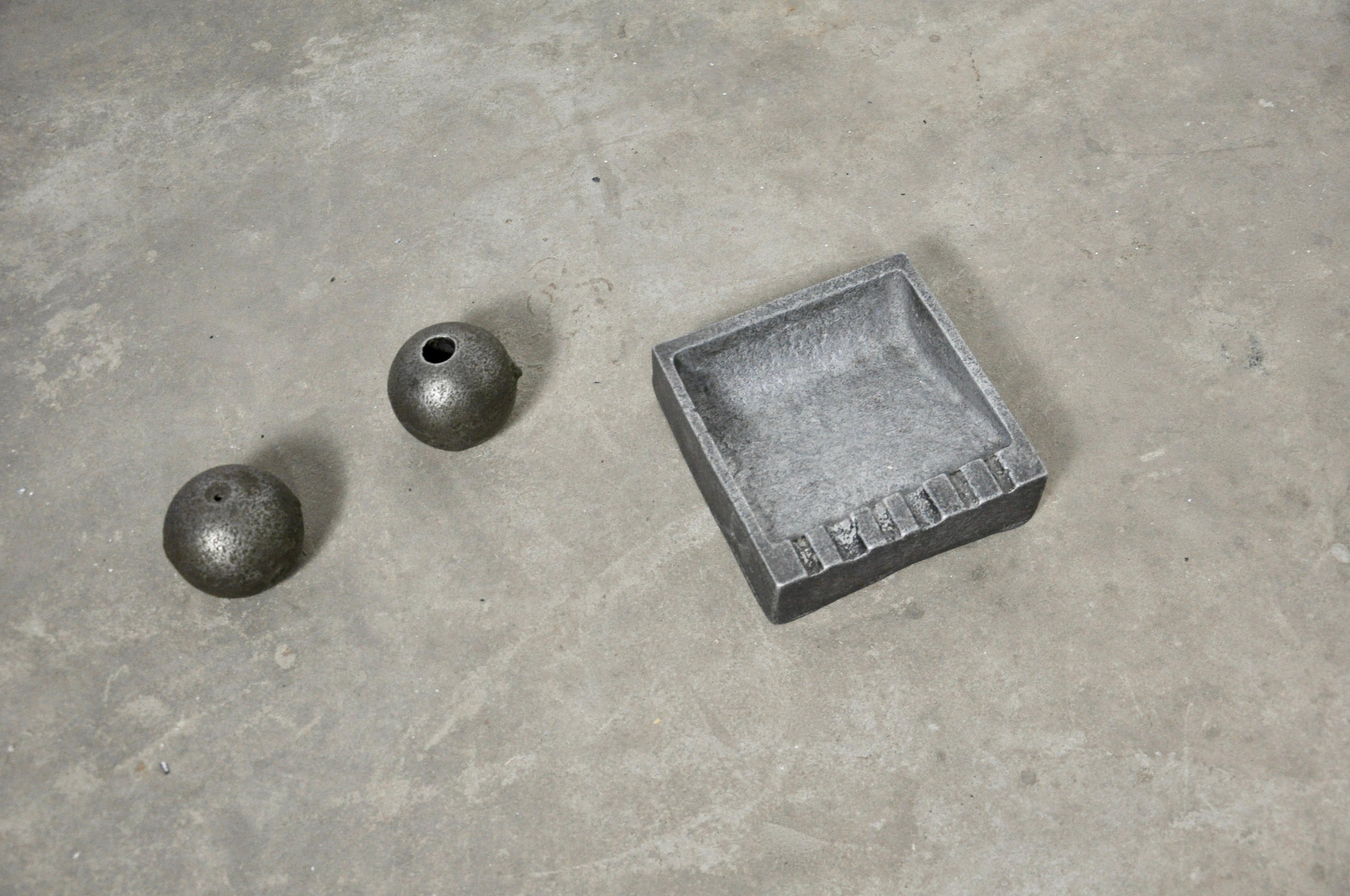 Brutalist set composed of an ashtray, a paper press and a candleholder in cast aluminium.