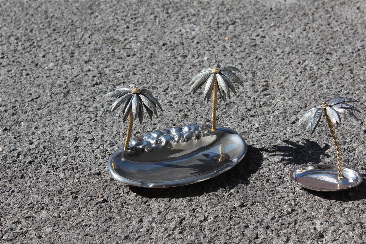 Ashtray with matchstick Italian design silver plate palm trees 1970 silver gold

Ashtray with matchstick Italian design silver plate palm trees 1970 silver gold. Measures: Matchbox height 11 cm, width 8.5 cm, depth 6.5 cm. Silver plate metal