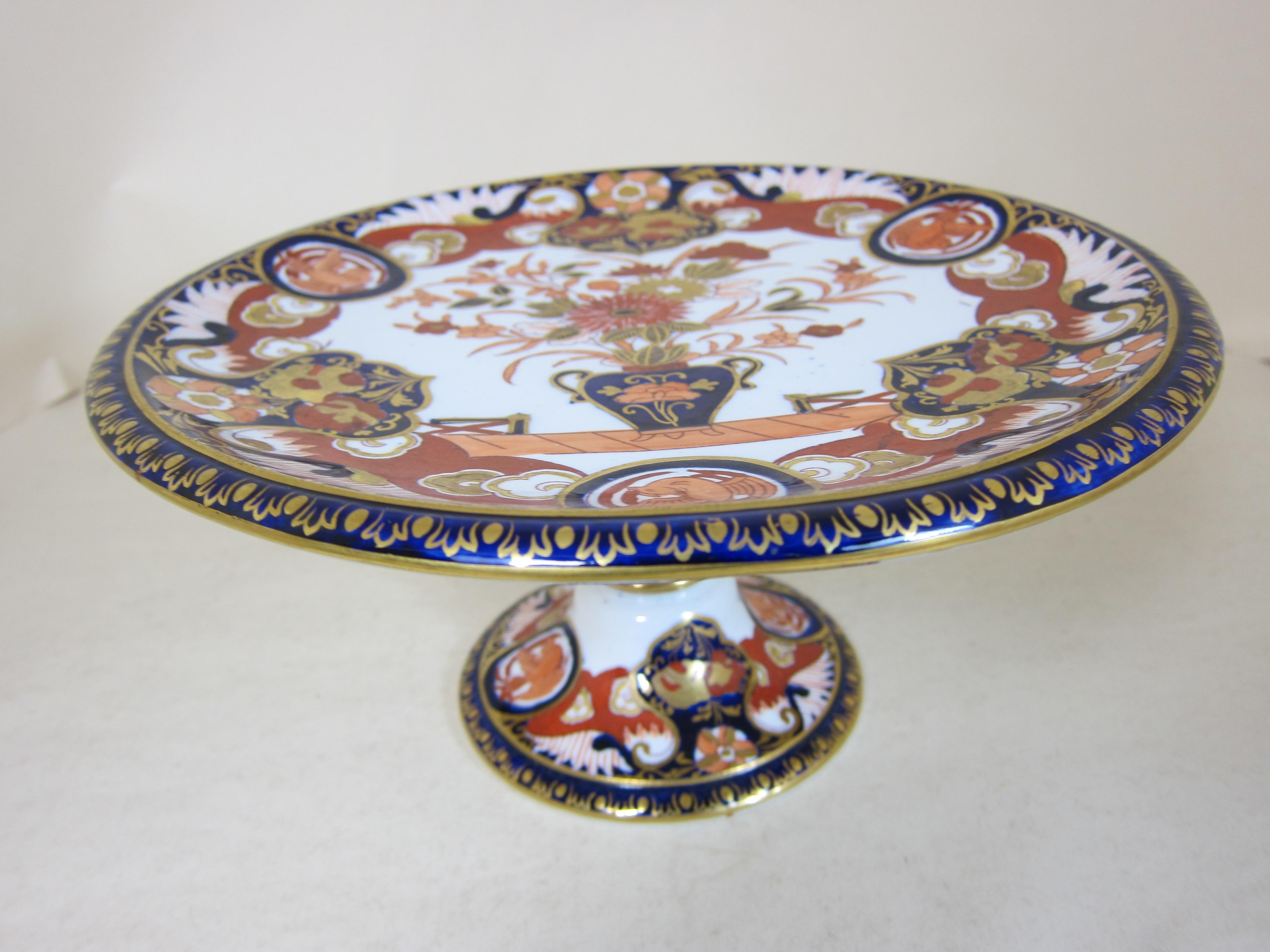 An Ashworths real ironstone dessert service decorated in Imari colours with a large vase with flowers.