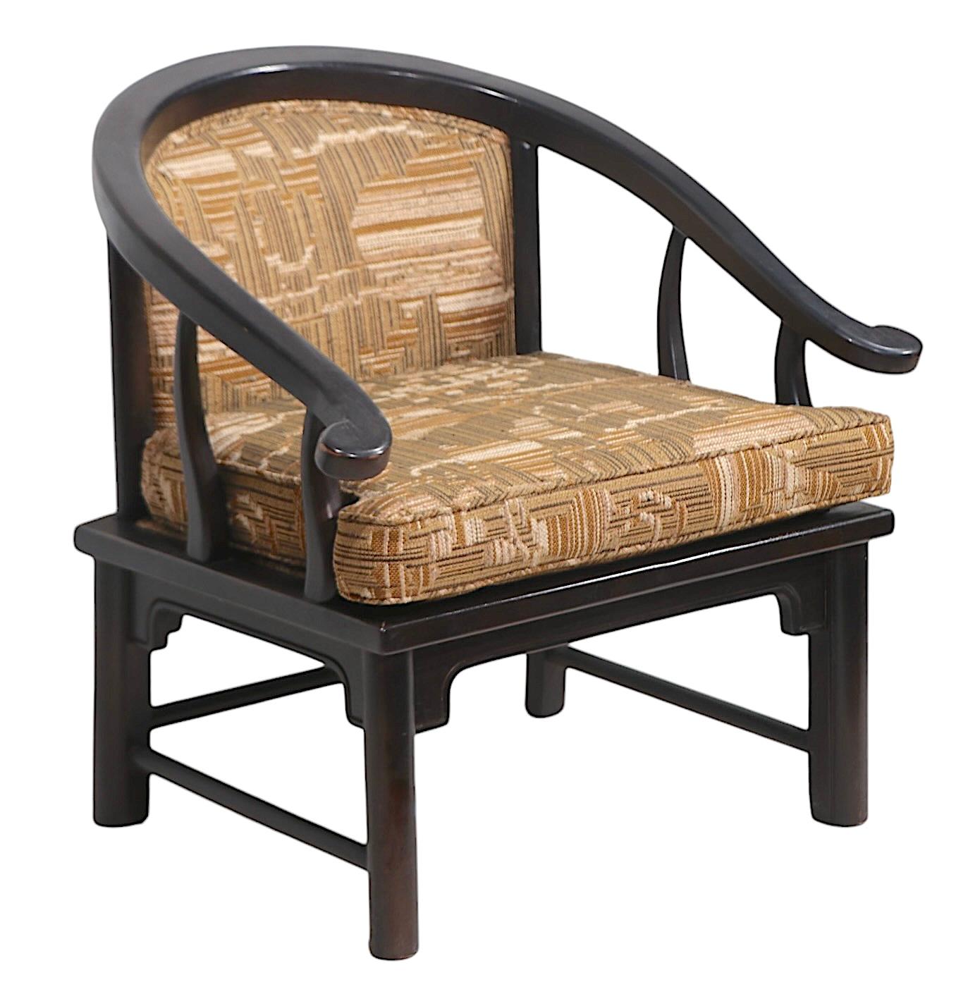 Voguish, chic, and sophisticated horseshoe style, Chinese influence lounge chair, attributed to the  Century Furniture Co. in the style of  James Mont. The chair features a solid oak frame, in original dark brown finish, with exceptional original