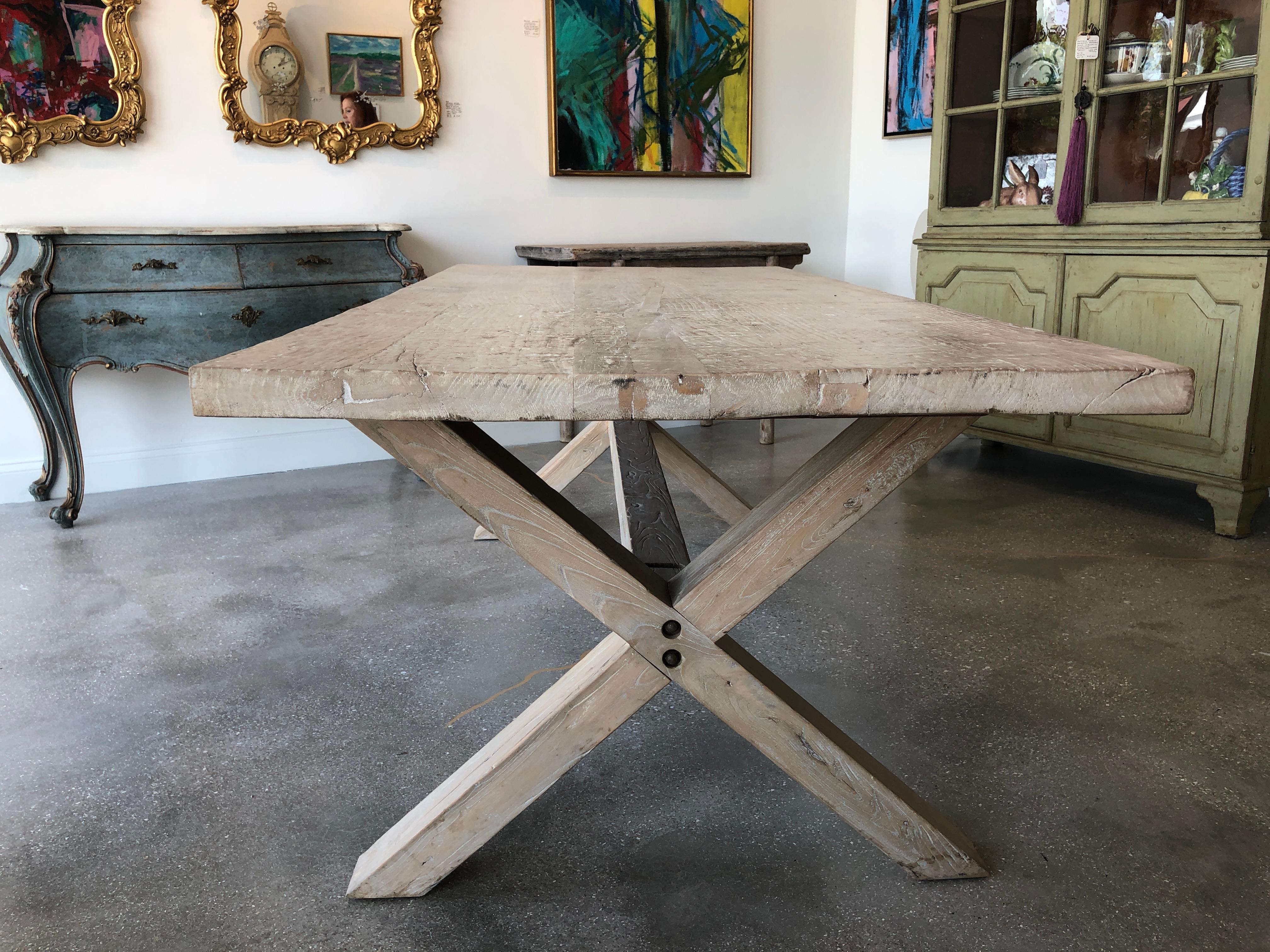 Organic antique Asian farm table in bleached poplar wood 19th century antique Asian door panel on top, X-shape base was made in 20th century with large center stretcher. Top has a wonderful roughhewn rustic patina.

Measures: H 29.25