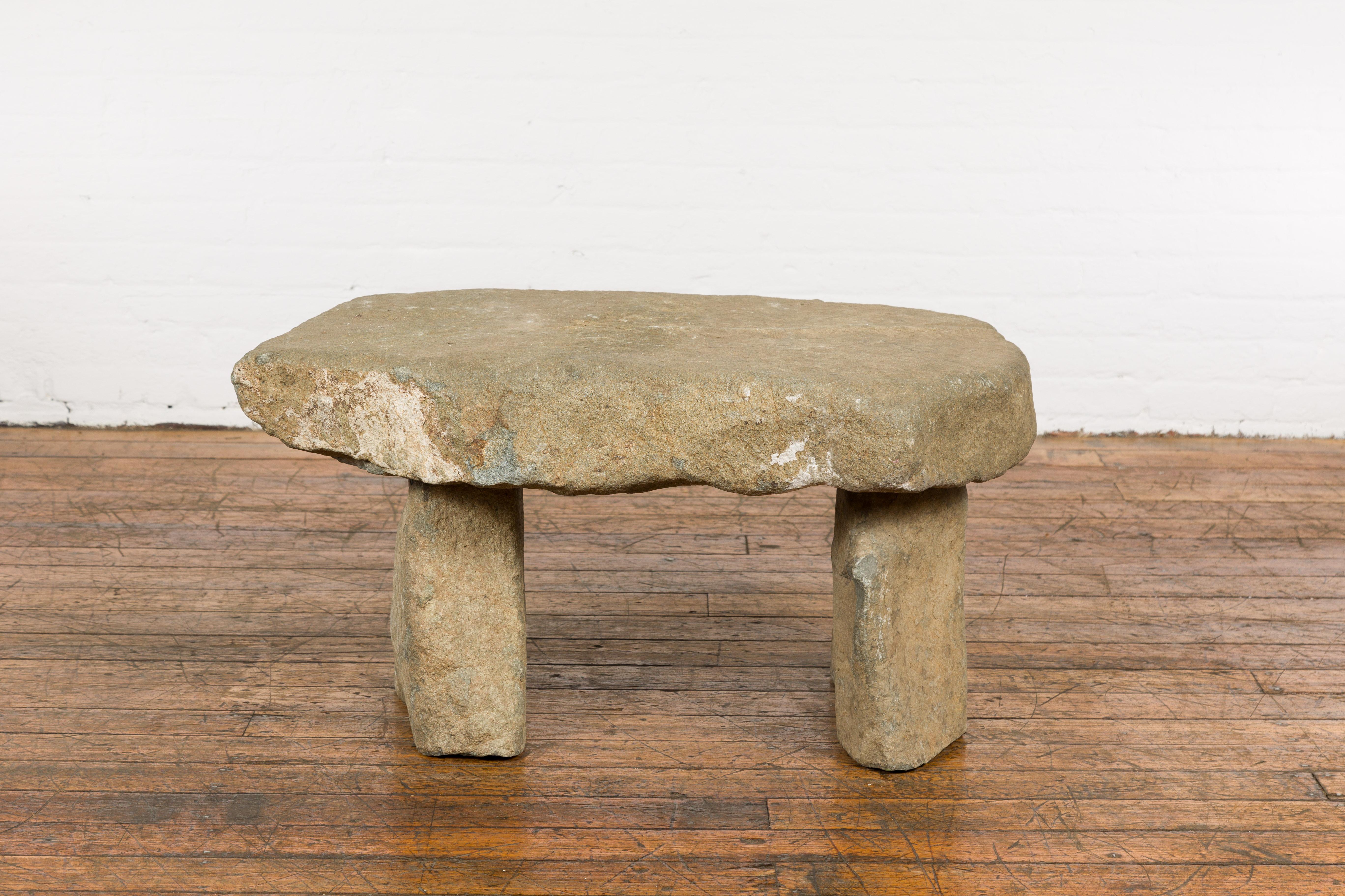 An antique asian stone bench from the 19th century, made of three separate pieces, with great rustic character. Created in Asia during the 19th century, this antique stone bench will bring an unpretentious presence in any garden. Made of three