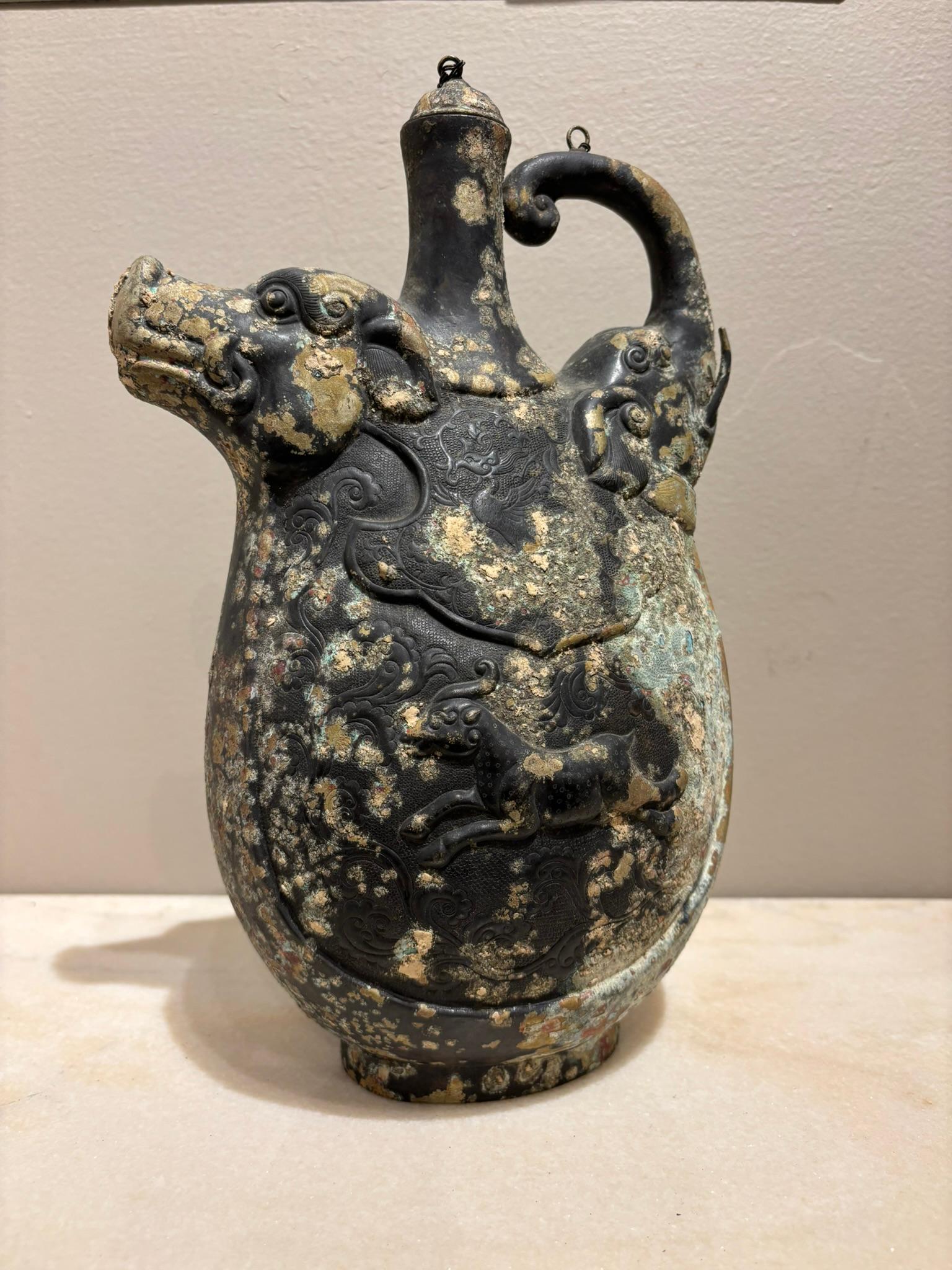 Chinese archaistic copper repousse ritualistic vessel with a boar head spout and elephant head handle. A beautifully crafted piece in the ancient style with intricate detail throughout. The spout is a formidable boar's head and the handle a
