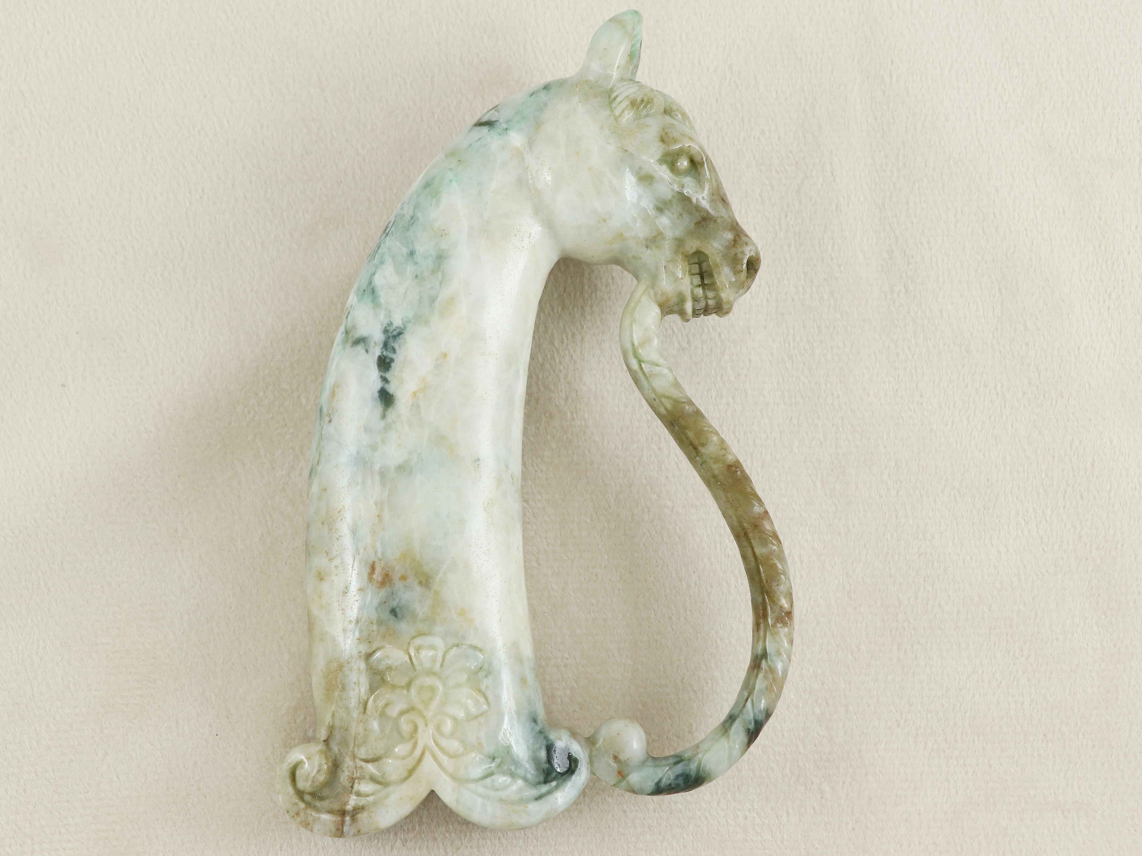 Una empuñadura tallada en jadeíta Piedras de jade originarias de Birmania, esta magnífica empuñadura está tallada en una sola piedra. 
La llamativa empuñadura está tallada en jade blanquecino verdoso y presenta unas proporciones perfectas. Tallado