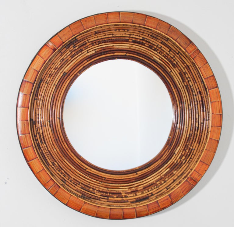 Vintage Organic Modern Asian Round Wall Bamboo and wood Mirror.
Beautiful round bamboo or rattan mirror with wood trim on the exterior edge and interior. 
The bamboo or rattan is in excellent condition and is a warm dark honey color. 
Variegated