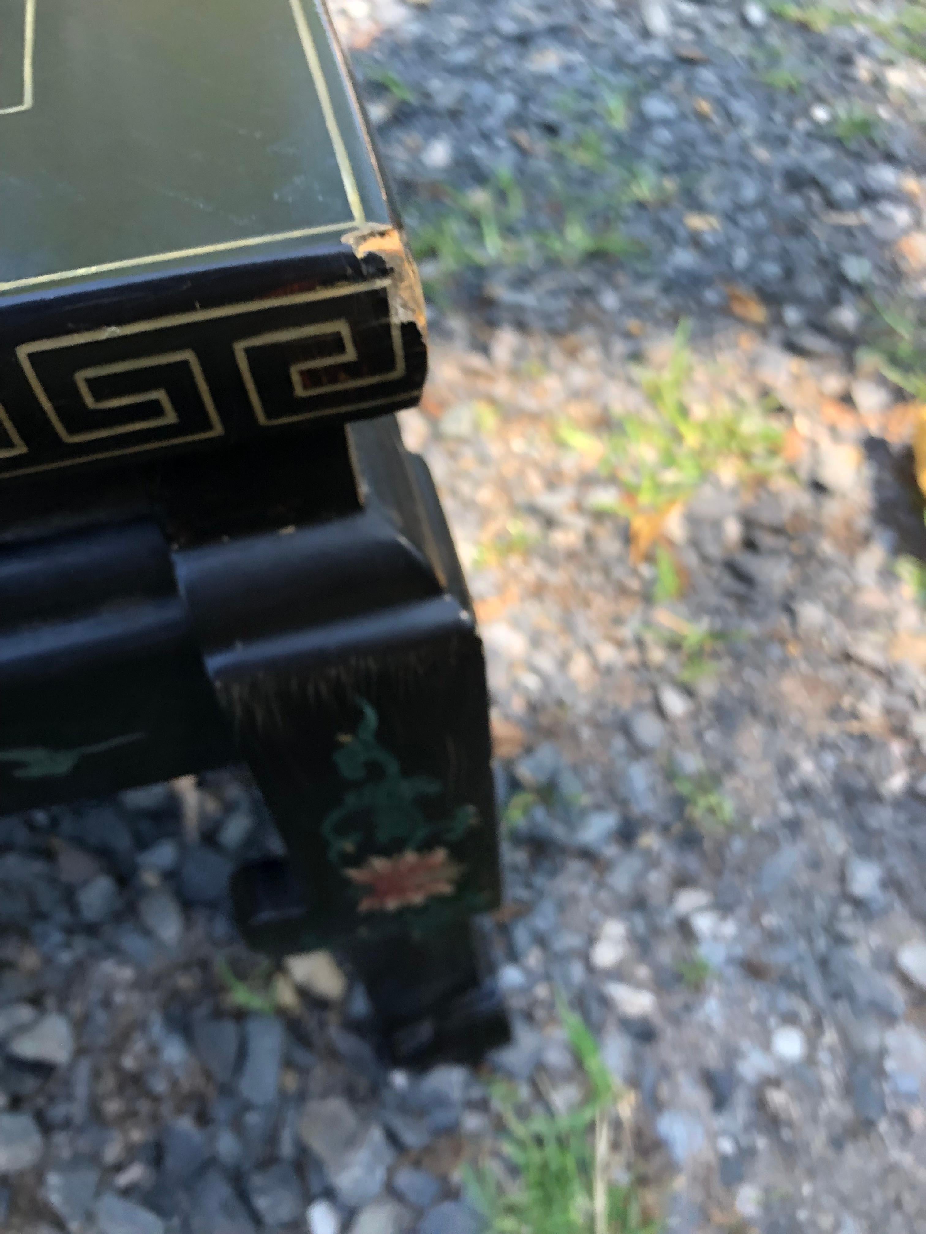 Elegante tavolino da caffè Asian Style dalla bella forma, con base in stile pagoda, sfondo nero e decorazioni in rilievo dai colori tenui di fiori e uccelli.  Il disegno della chiave greca in oro si trova alla periferia.