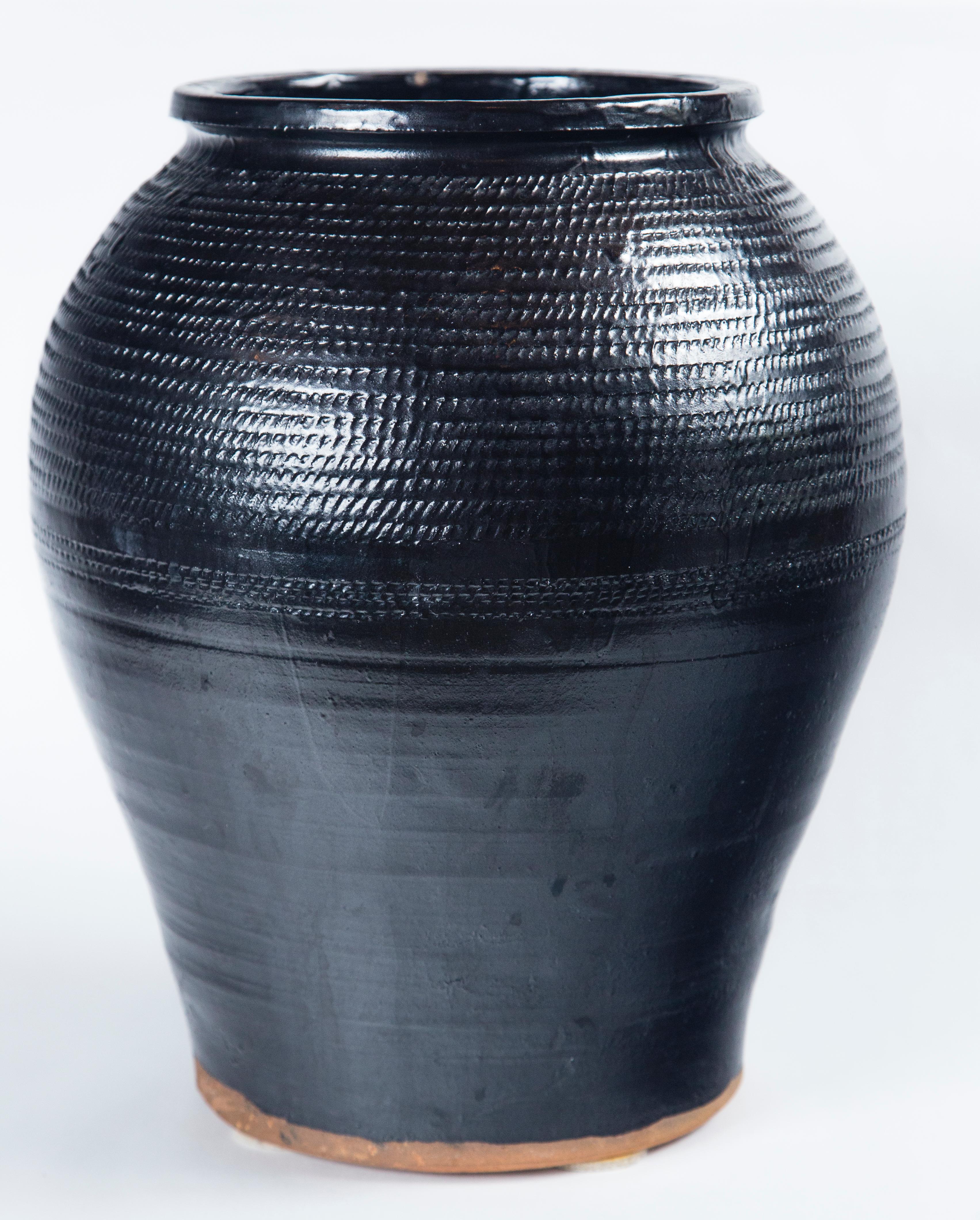 Asian black glaze ceramic storage jar, 20th century. Large size container with overall incised design.