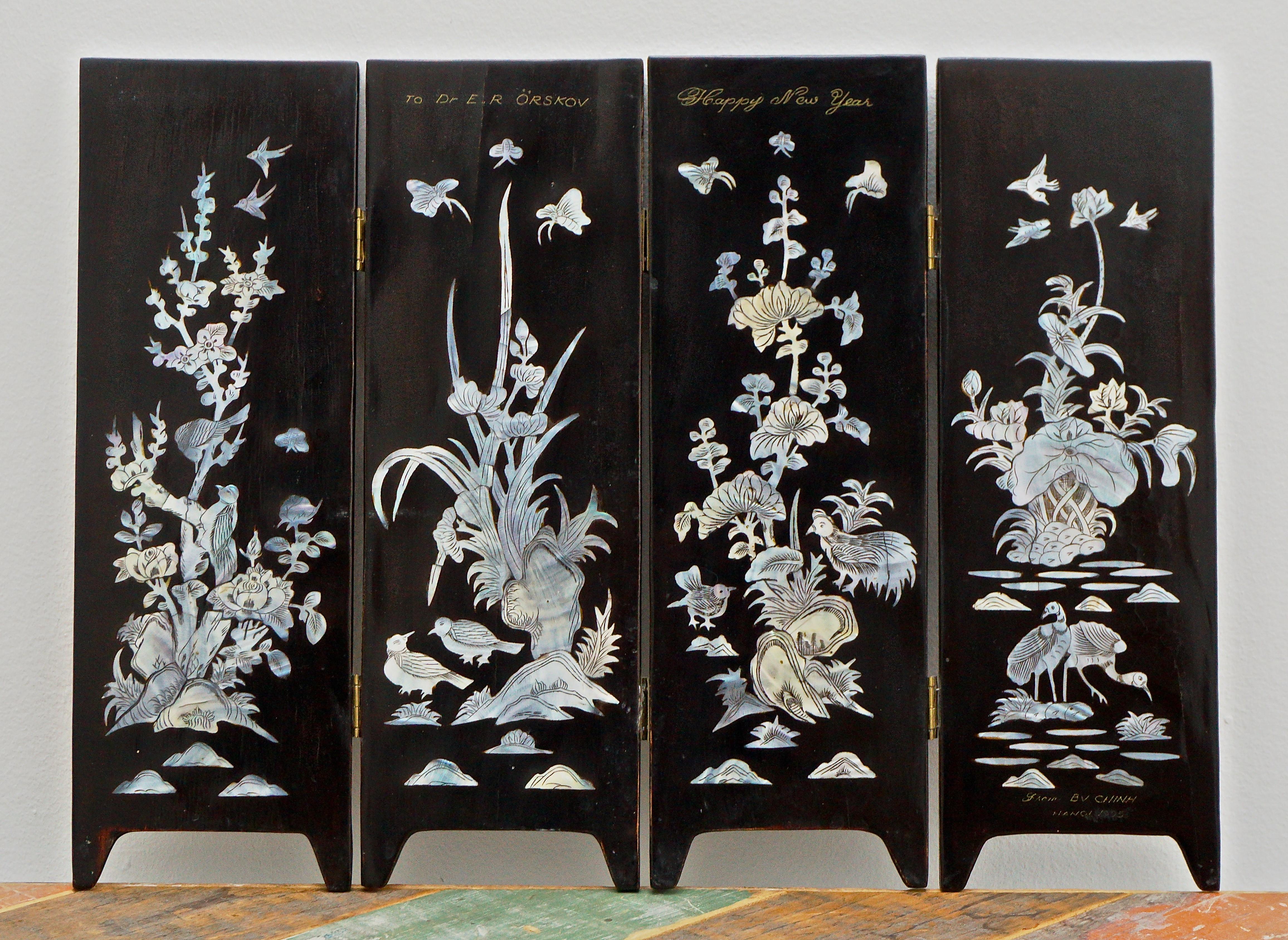 Asian four panel black lacquer table screen, featuring beautiful inlaid mother-of-pearl flower and bird decoration. Measuring height 29.7cm / 11.69 inches and width 40.5cm / 15.94 inches. The screen is marked Hanoi 1995. There are some signs of