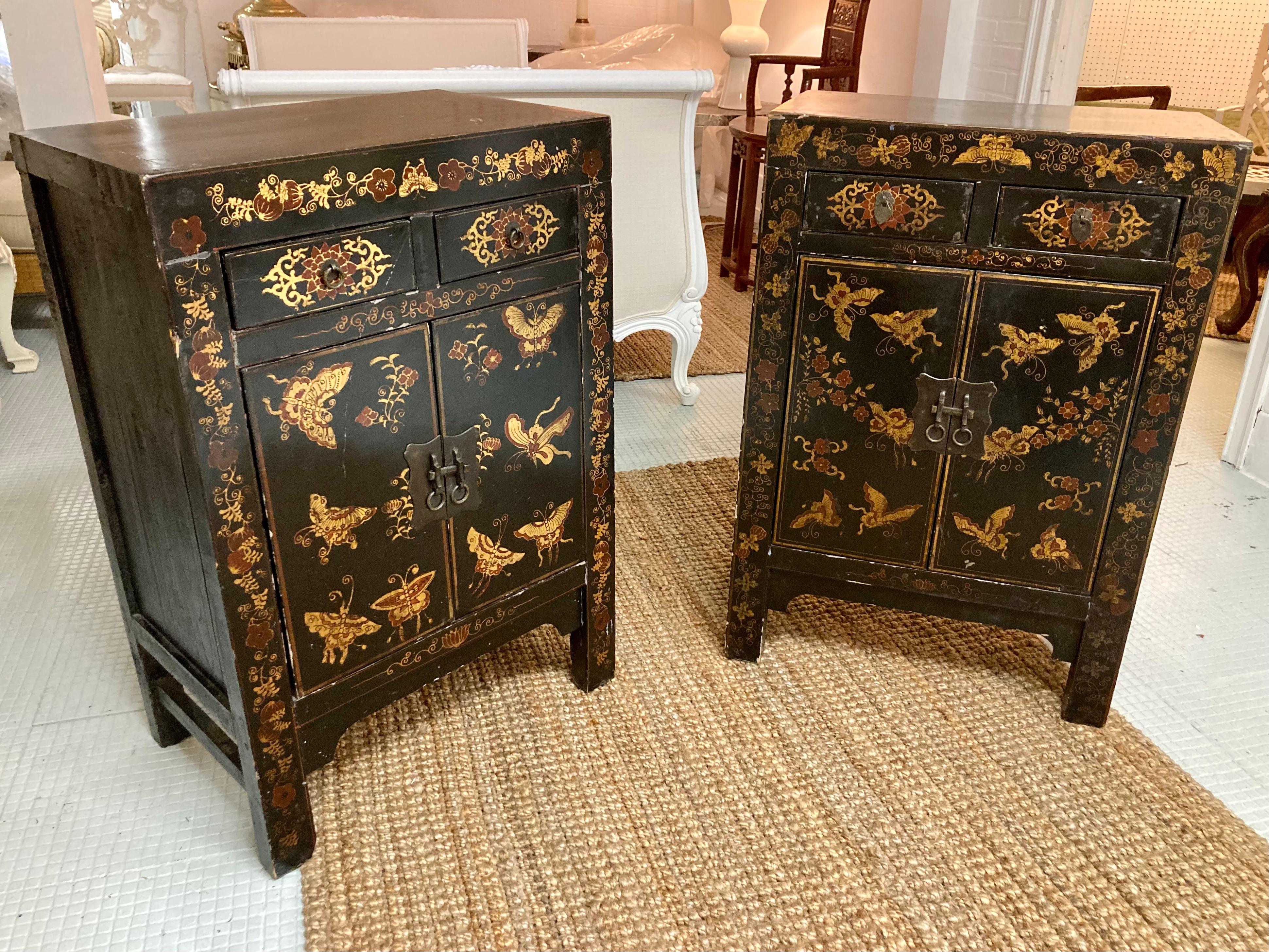Bellissima coppia di credenze asiatiche laccate di nero con farfalle dipinte a mano.