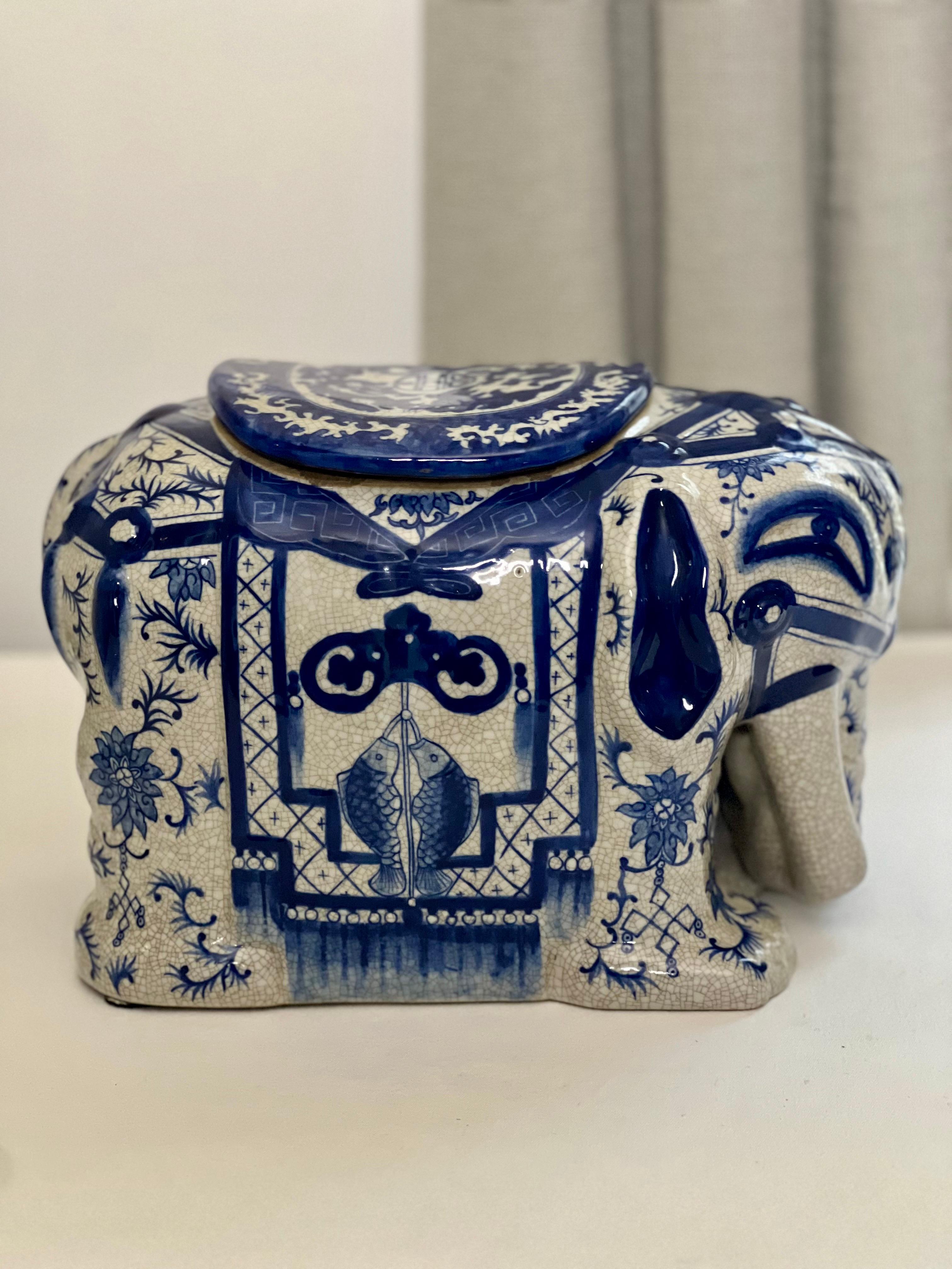 Unique et charmant vase ou boîte à couvercle en forme d'éléphant en céramique asiatique bleue et blanche à glaçure craquelée, 20e siècle. Magnifiquement décorée sur toute sa surface, avec un couvercle ajusté sur le dessus de la selle, de poissons