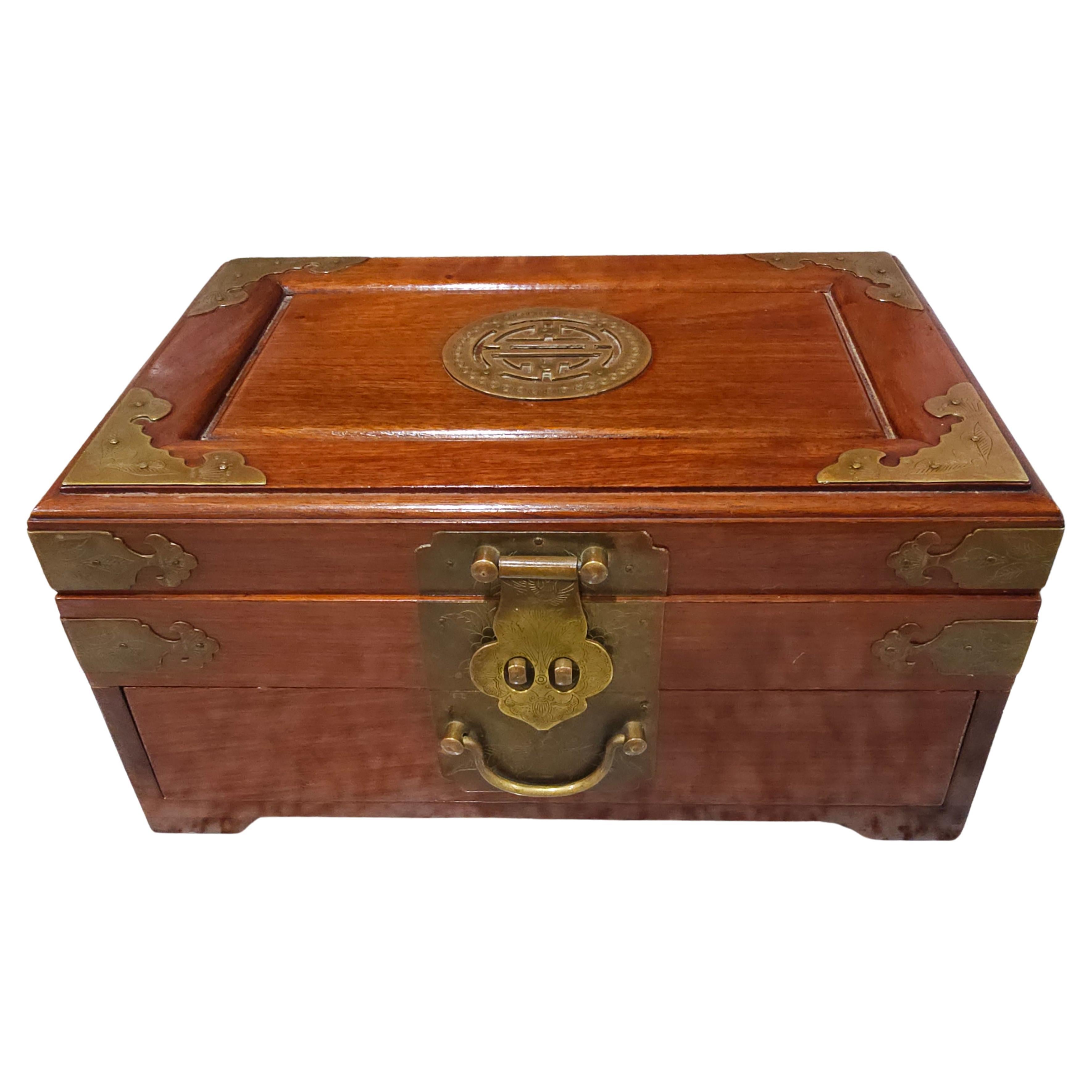 This is a Chinese jewelry box that is made out of rosewood with beautiful Chinoiserie brass trim. It is a nice heavy box that measures 12”W x 8”L x 6”H. The top layer inside holds 5 small compartments with 3 felt lined.  The bottom layer / Drawer