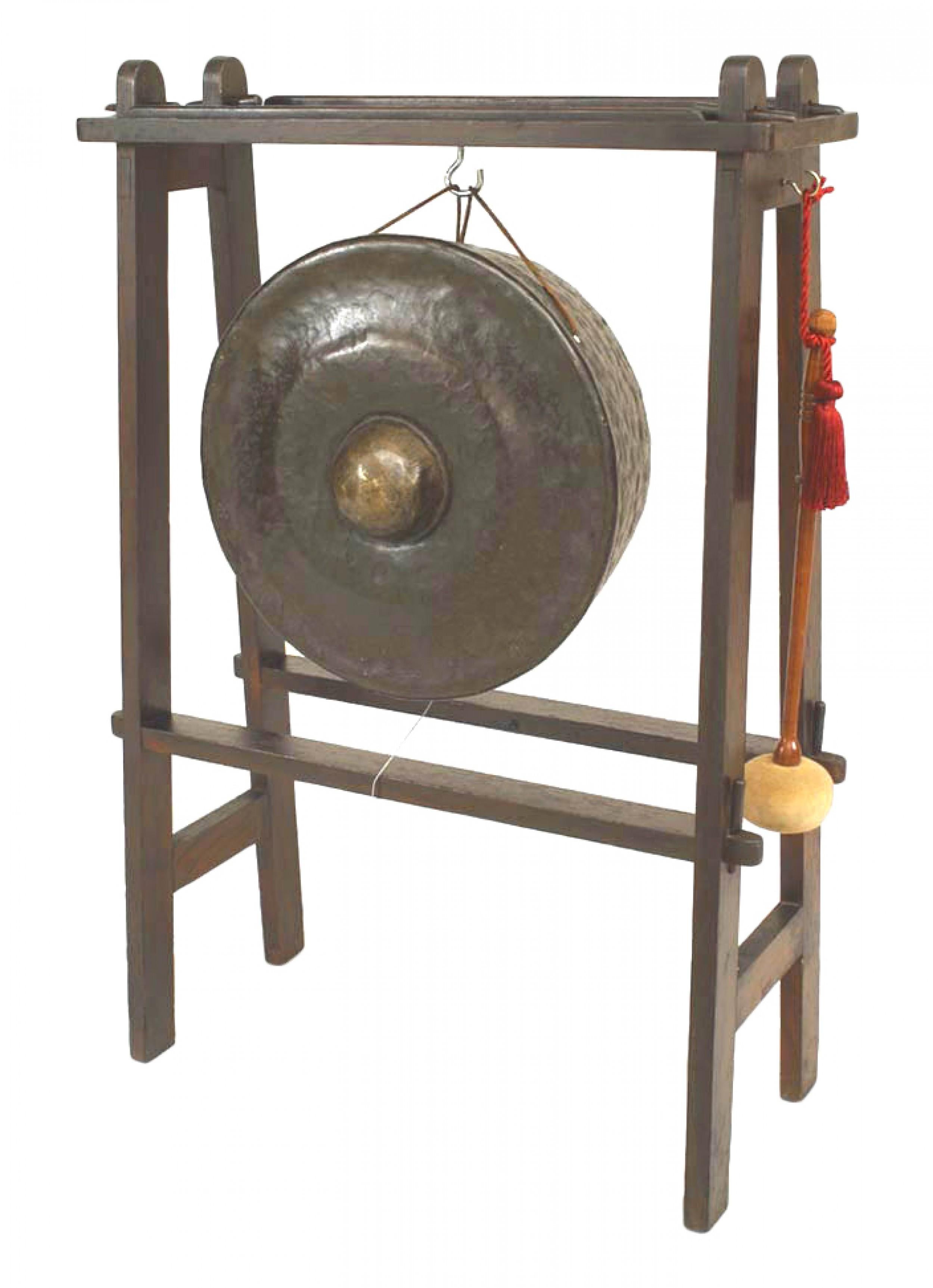 English Art & Crafts stained oak stand supporting an Asian bronze gong with striker.