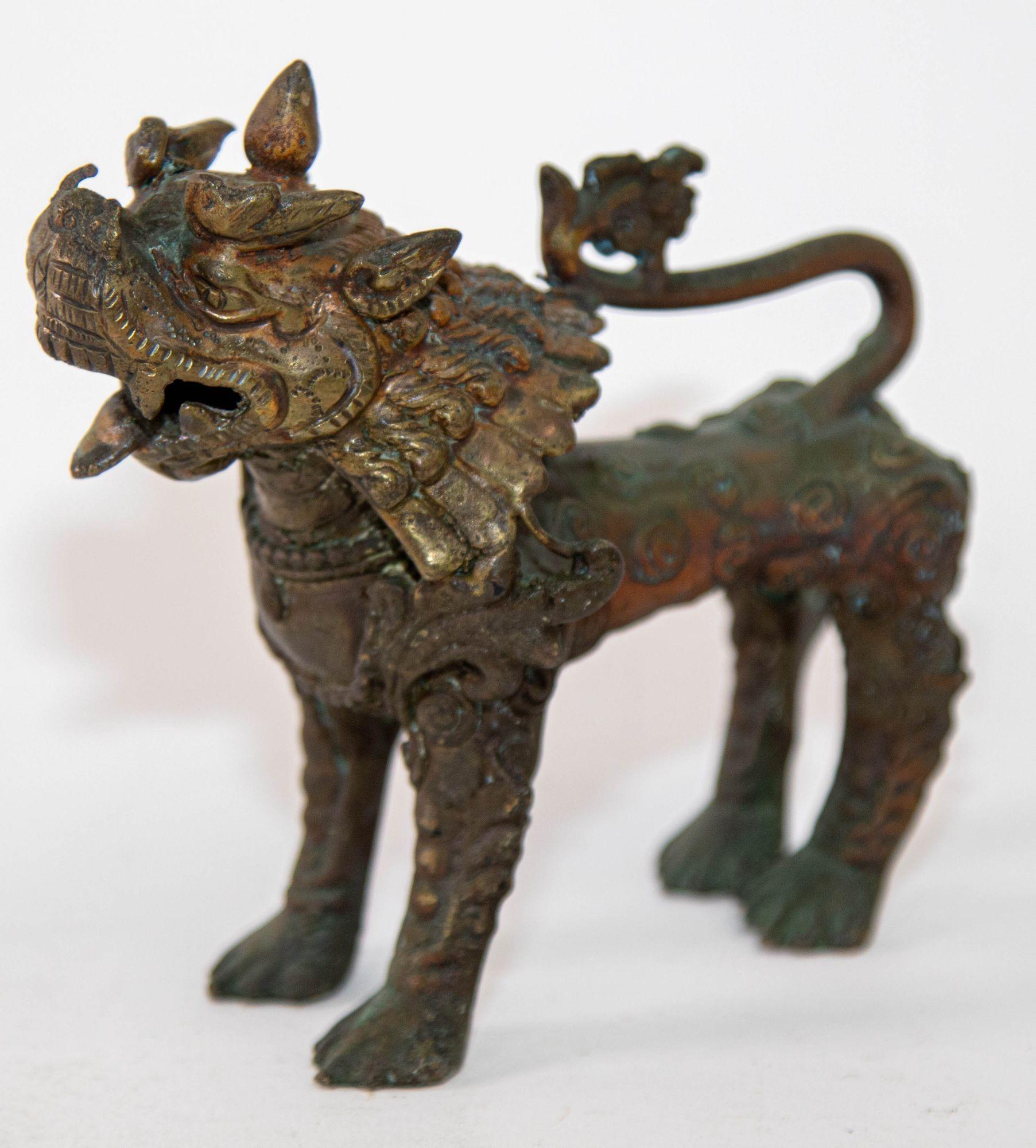 Antique Asian bronze guardian lion Lion Sculpture, Nepal 19th Century.
A bronze figure with traces of polychromy depicting a temple guardian lion with an open mouth, long mane and a defensive posture on its four outstretched legs.
The tail is curled