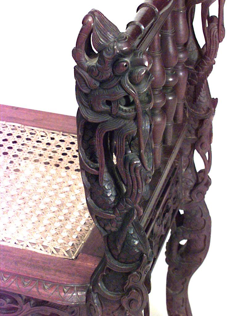 Asian Burmese style (19th Century) carved walnut bench with carved spindle side arms and cane seat.
