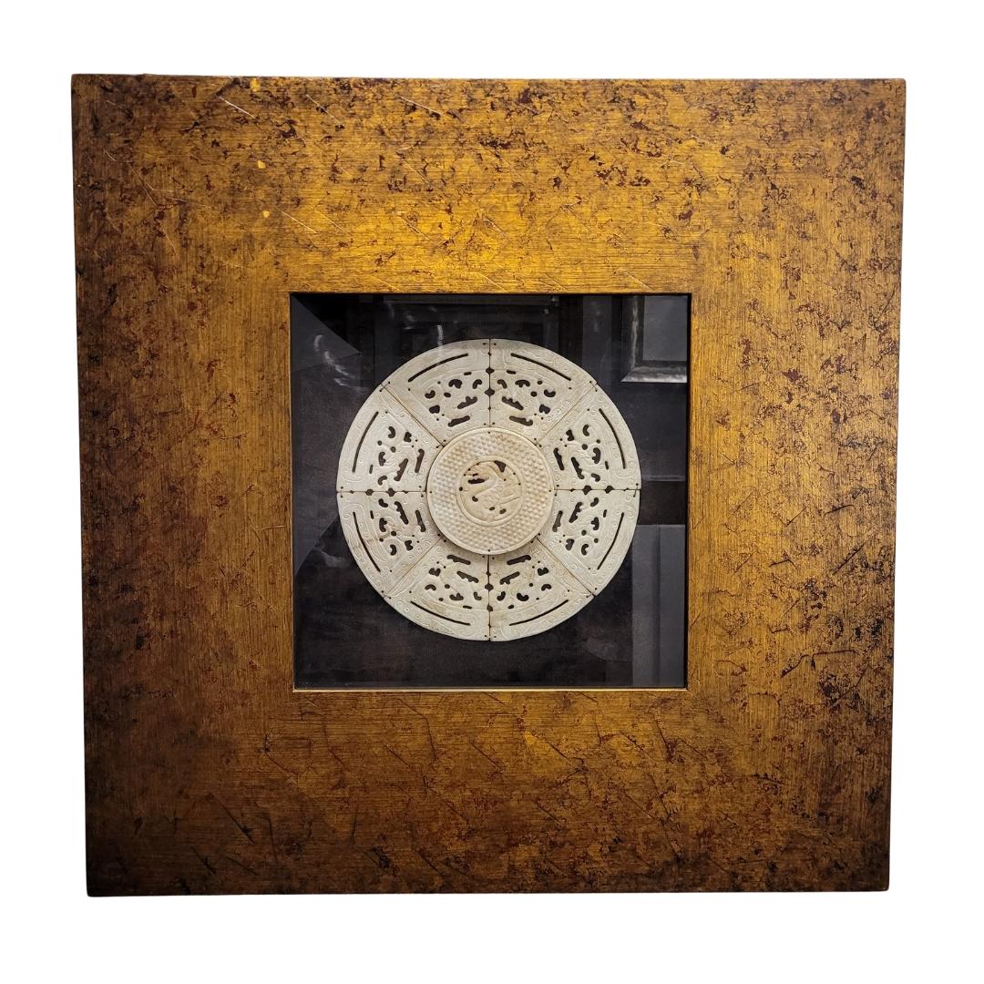 Exquisite carved and framed jadeite bi disc (璧). A bi disc is a circular (flat) jade disc with a hole in the center, used in ancient China. In this case, it is composed of eight pieces that make up the shape of the bi and a final circular piece in