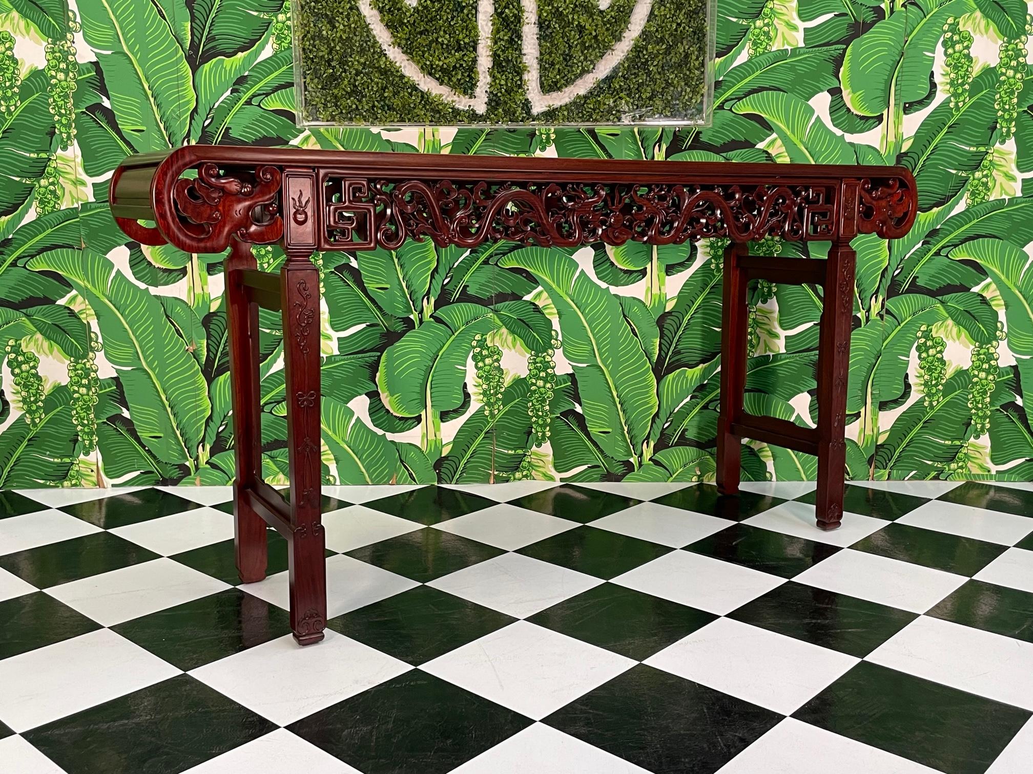Asian console table features hand carved images of dragons along the frieze and decorative carved legs. Stands 38