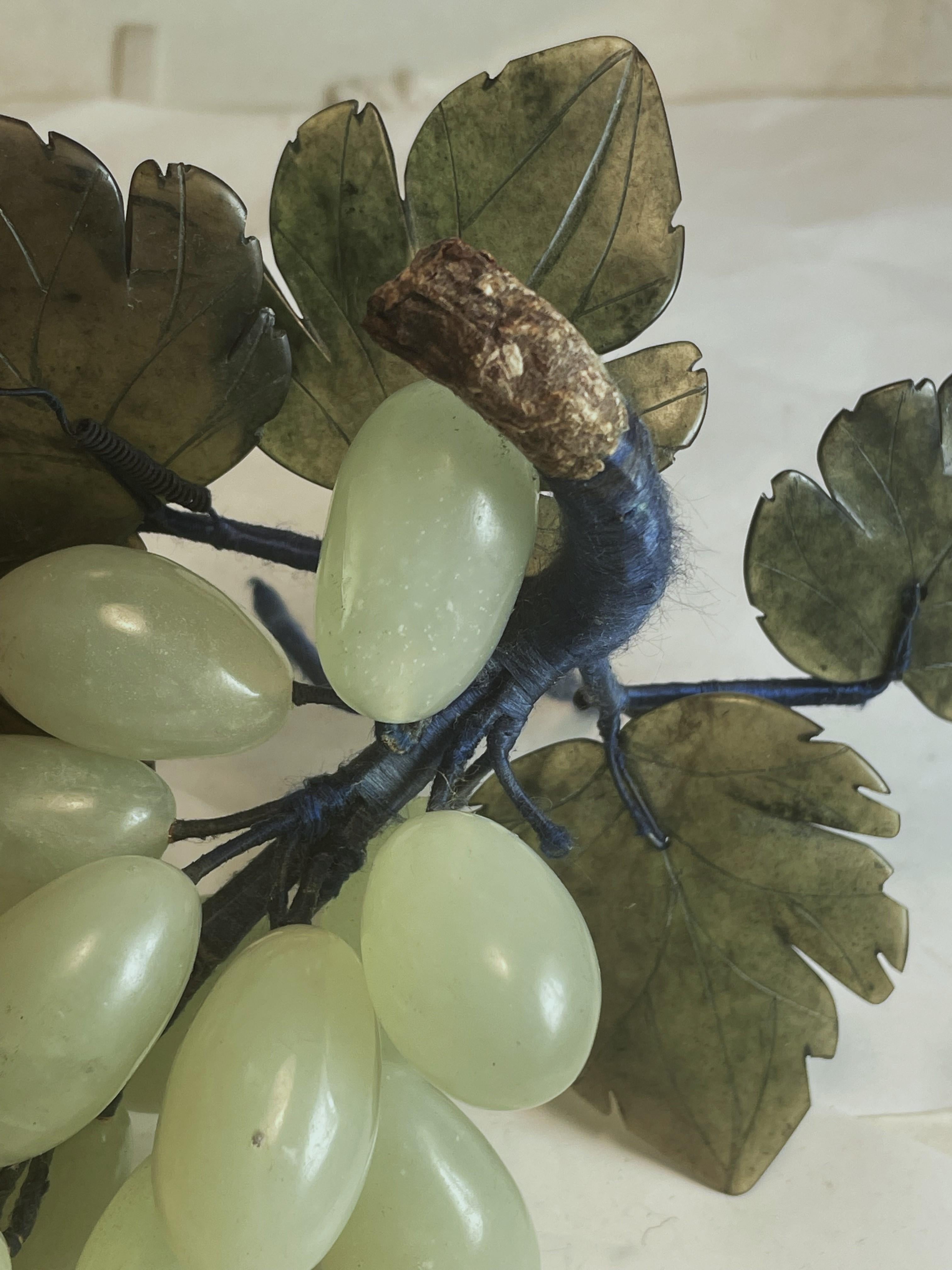 Se trata de un racimo de uvas tallado en jade de forma realista, con hojas talladas en jade más oscuro. La red del tallo está envuelta en alambre con cordón de satén azul y el extremo donde se habría cortado de la enredadera es de imitación madera.