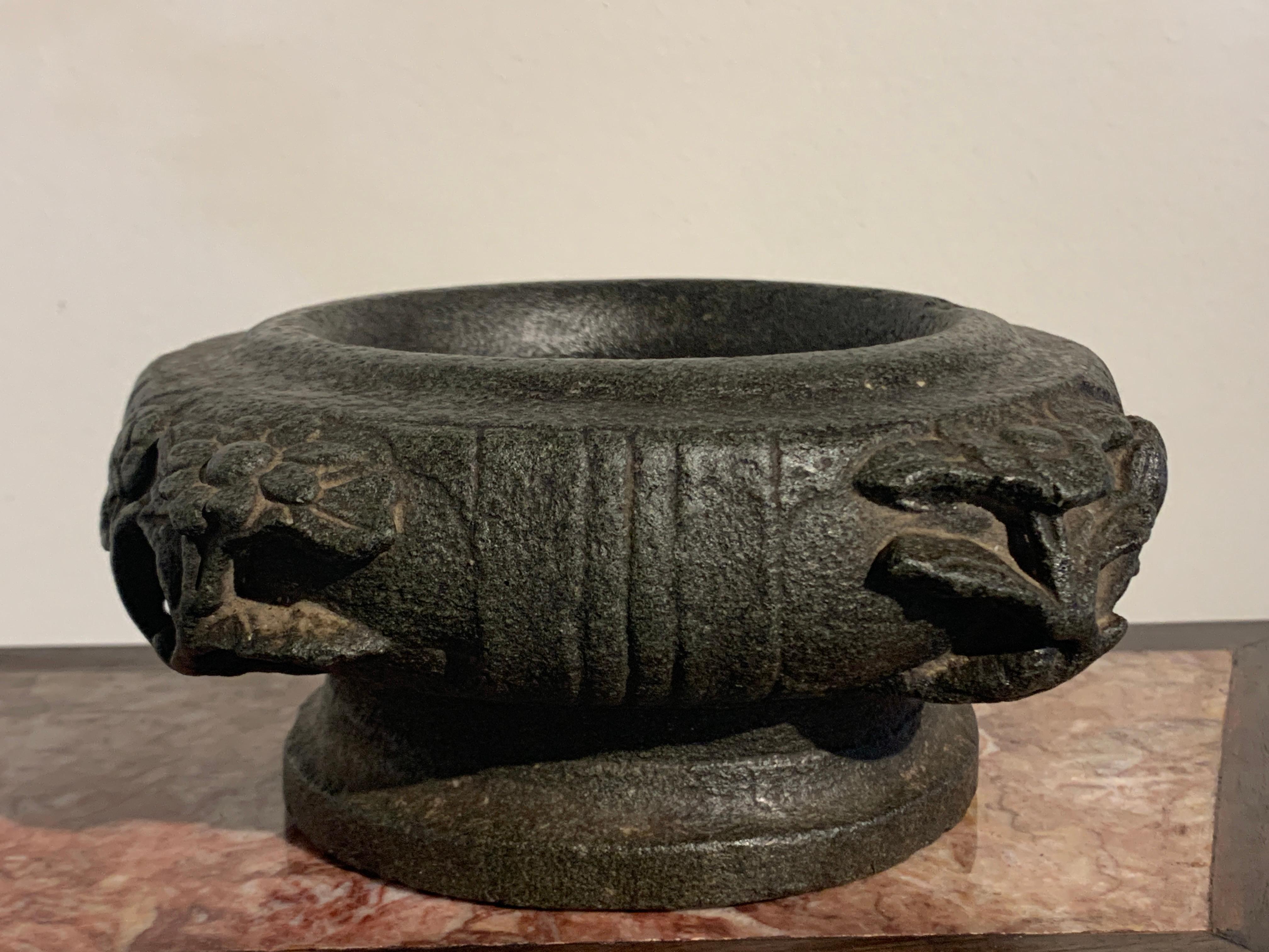 An unusual carved stone jardinière, or possibly a mortar, 19th century or earlier, Asia, possibly China.

The jardinière of shallow bowl form, with wide, thick walls, and set upon a flat, pedestal foot. Carved from a single block of dark