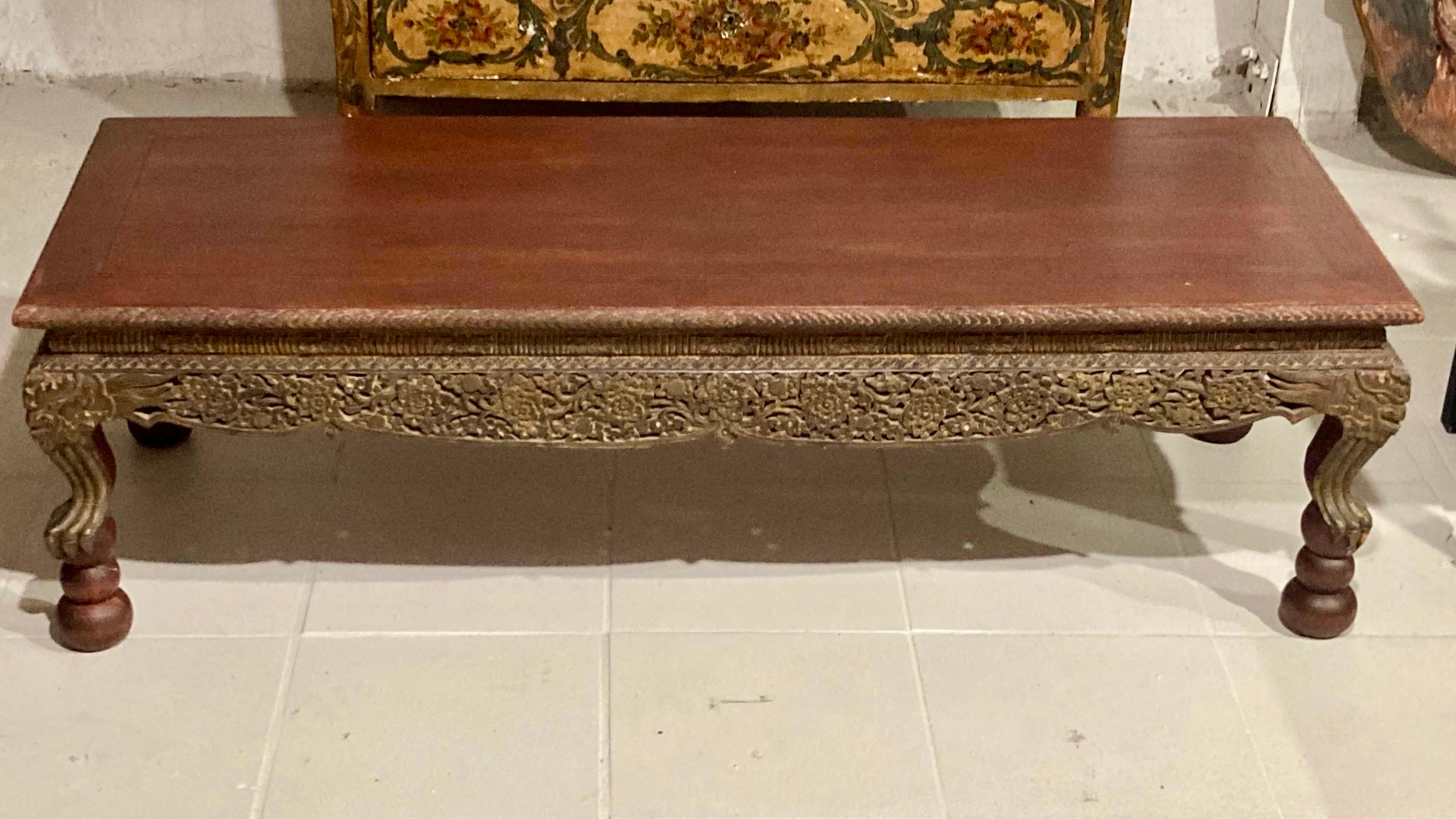 Beautiful Asian carved wood coffee table with nice detail work. Very pretty finish on the surface. Nice simple top to highlight the carving details. Fun fact: the table is from the Estate of Kirk Douglas.