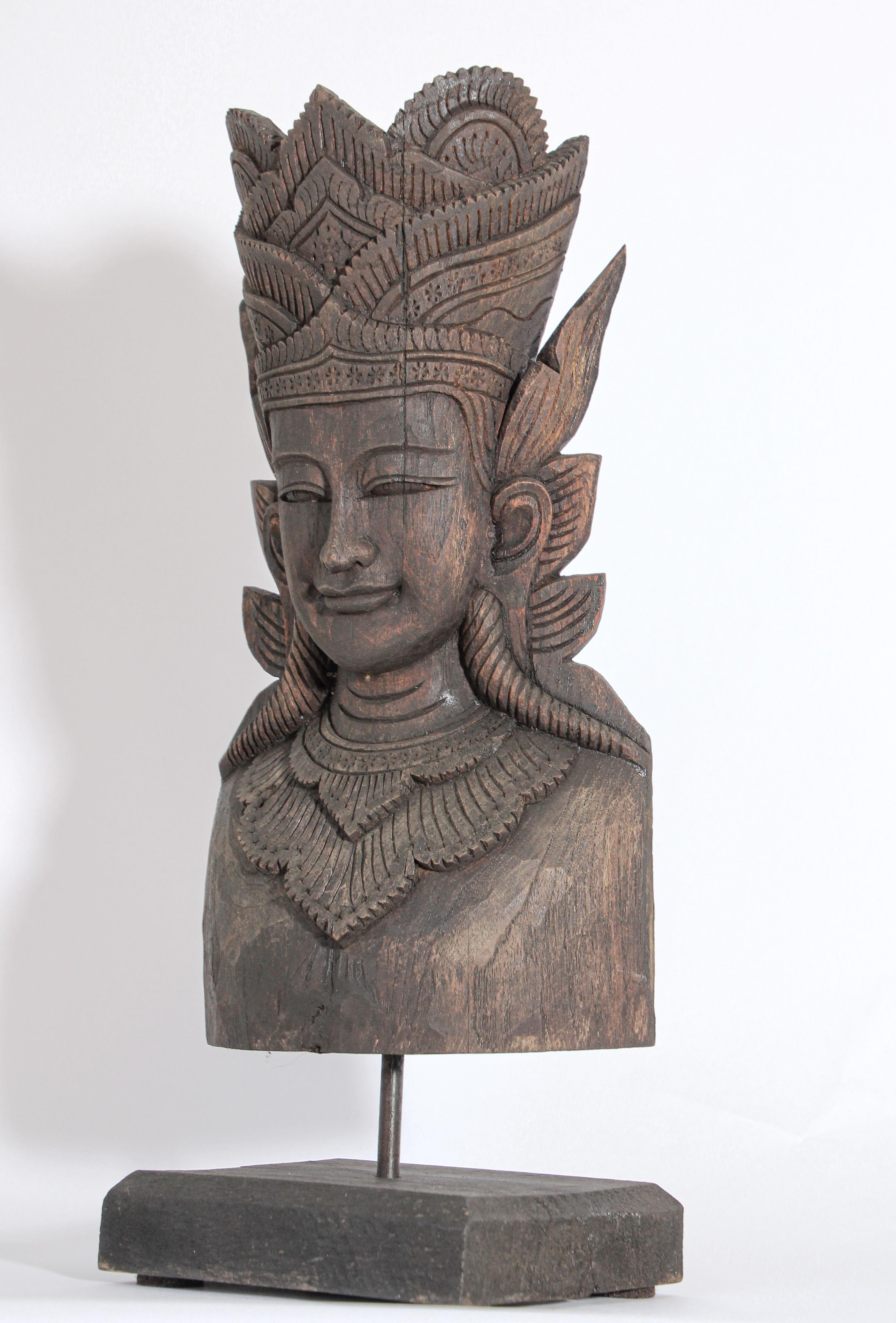 Intricate and ornate, this eye-catching wood sculpture depicts a Buddha head from Nepal.
Mounted on a black-painted wood stand.
Buddha shows a serene, peaceful expression with slender, incised lips flanked by pendulous earlobes and wearing a