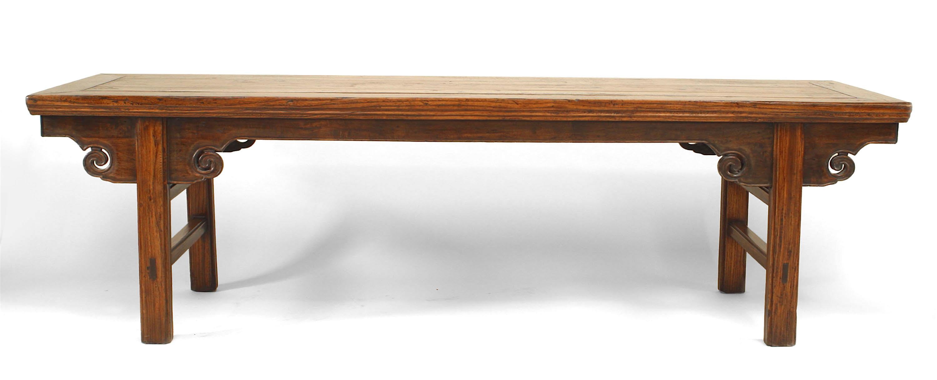 Table basse/de jour en bois d'orme (yu-mu) grainé d'Asie chinoise (province de Shanxi) du milieu du XIXe siècle, avec un plateau massif et des volutes sculptées en forme de nuages de chaque côté des pieds sur le tablier.
 