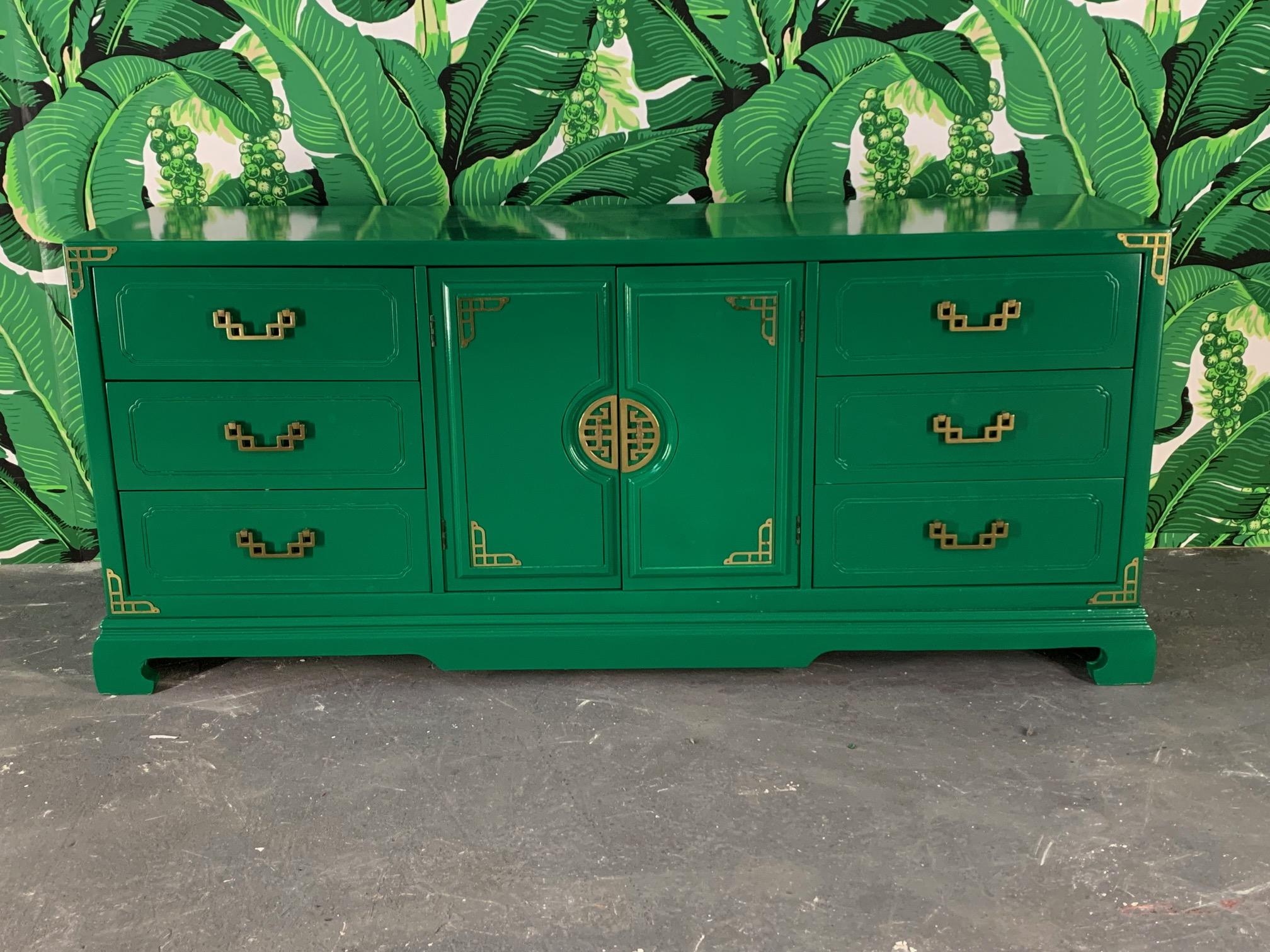 Chinese chinoiserie style buffet in high gloss green lacquer with original brass hardware.
Six drawers flank center two doors when opened, reveal three additional interior drawers. Strong Ming style leg base. Made in the USA. Very good condition