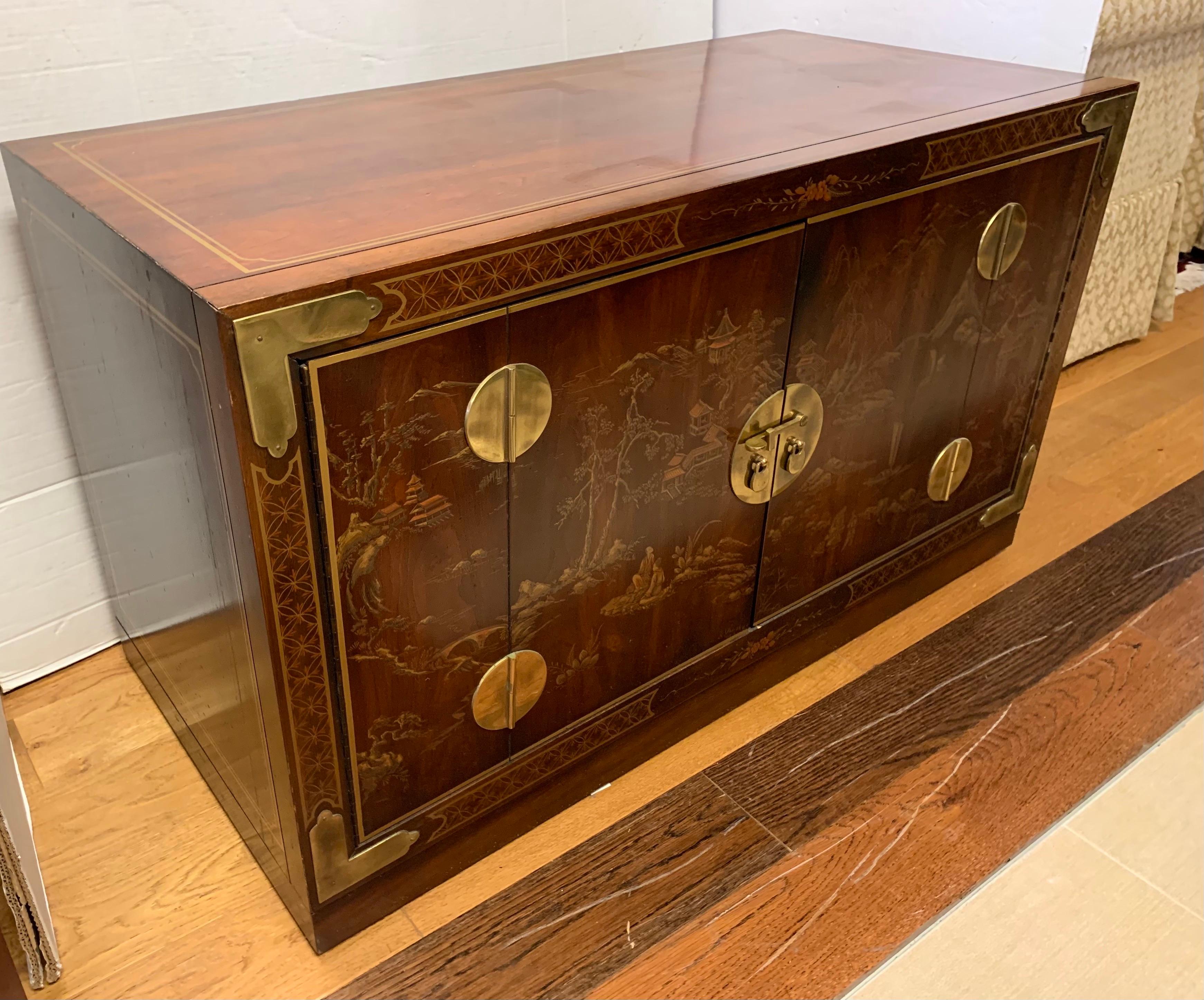 Multi-purpose chinoiserie low cabinet which can be used as a media cabinet, bar, buffet, or in your foyer for storage. It's good to have choices. It features brass hardware and hand painted scenery on the front doors.