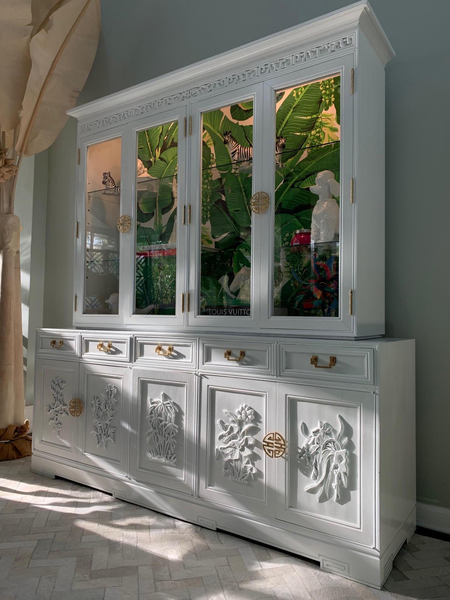 Asian Style lighted china hutch by Ricardo Lynn finished in high gloss white lacquer and Dorothy Draper Brazilliance wallpaper. Features brass hardware and ample storage. Excellent vintage condition with minor imperfections to the newly lacquered