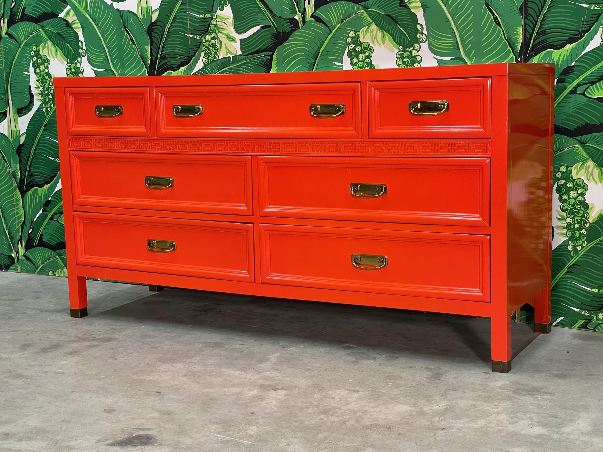 Seven drawer dresser from Dixie Furniture's Shangri La collection features brass hardware and three dimensional fretwork. Lacquered in high gloss Hermes orange. Good condition with minor imperfections.
      