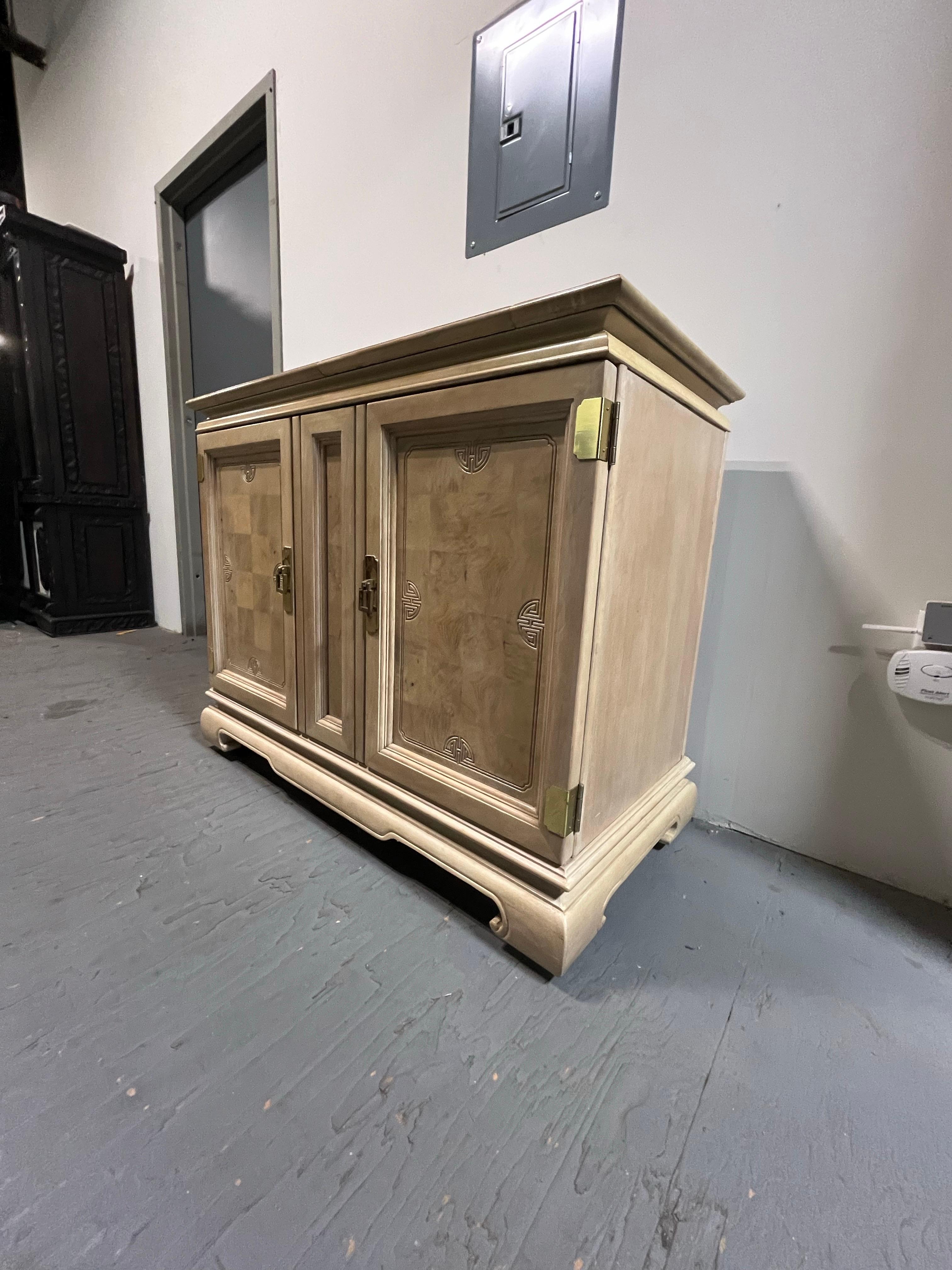 Server ribaltabile in stile asiatico Drexel Heritage in legno di Oak chiaro con ante rivestite in legno di radica con incisioni. Presenta ferramenta in ottone e gambe in stile Ming Ming. Due porte con ampi spazi e due cassetti interni. Area di