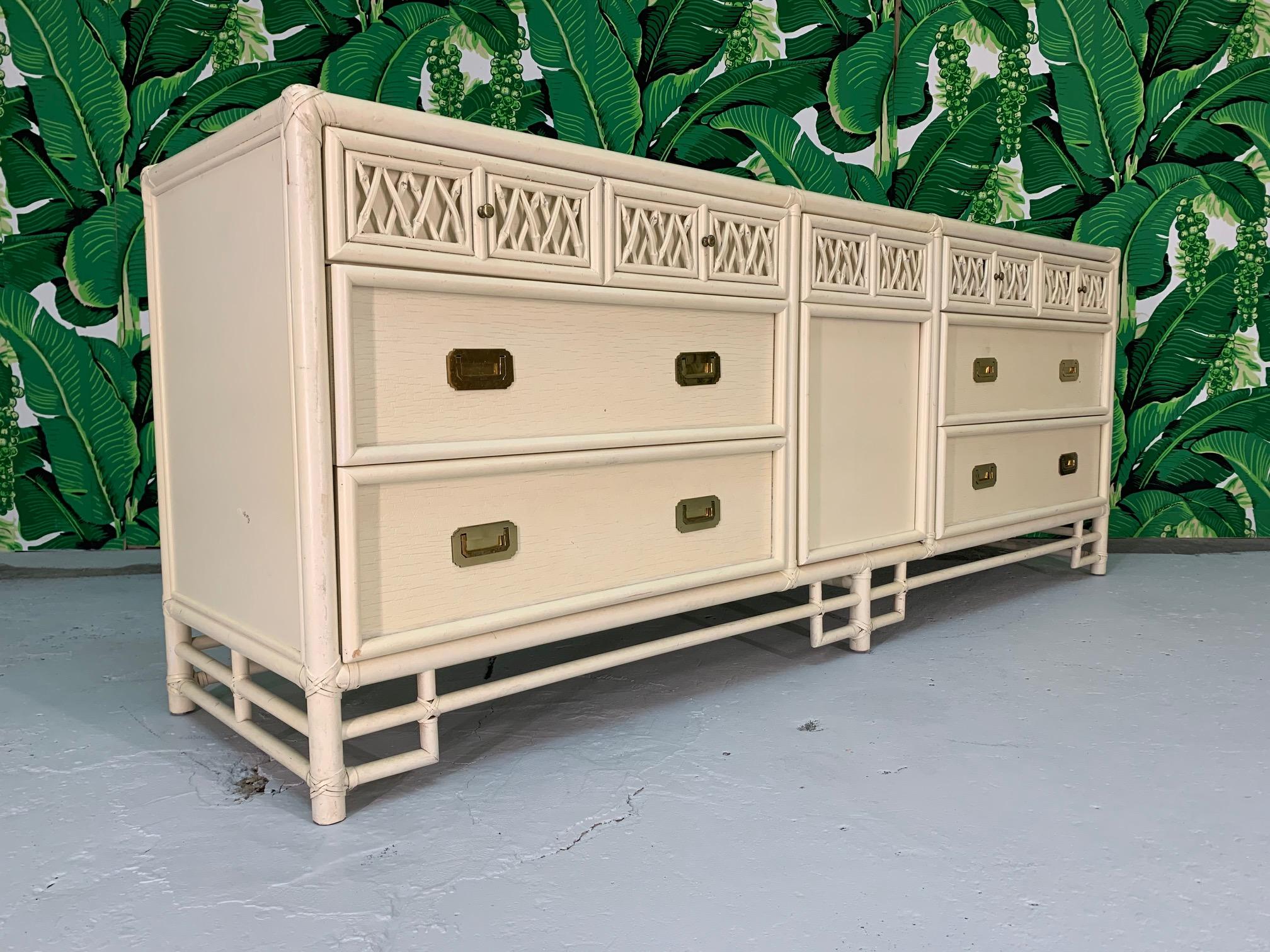 Vintage bamboo dresser features rattan lattice drawer fronts and brass hardware. Cream colored finish. Good vintage condition with minor abrasions to finish, structurally sound condition.