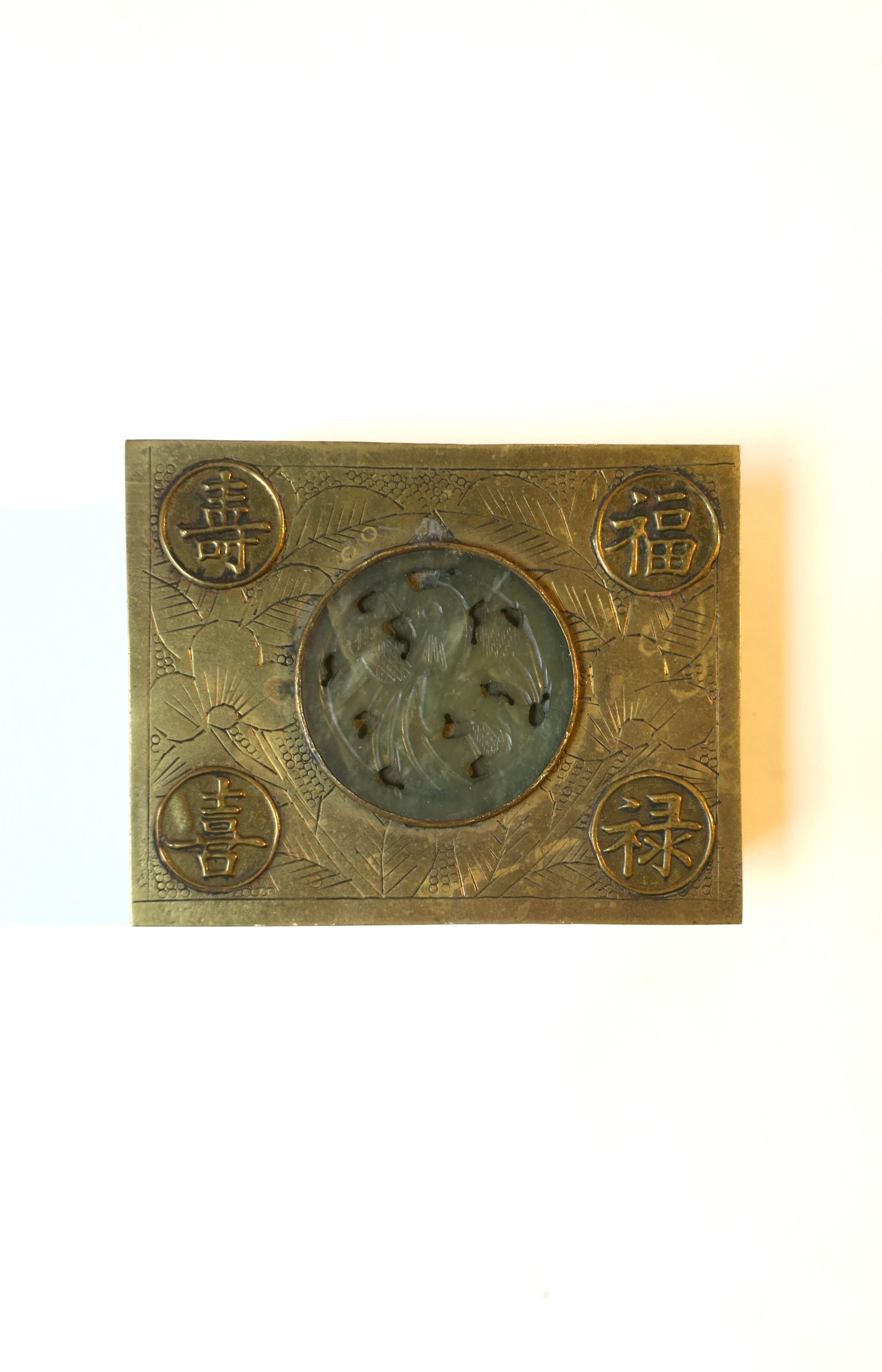 An Asian brass cigarette box with serpentine stone and hand engraving, circa mid-20th century, China. This brass box has a teak wood lining, a round centre serpentine stone that resembles jade, and hand engraved with leaves and flowers. Piece is
