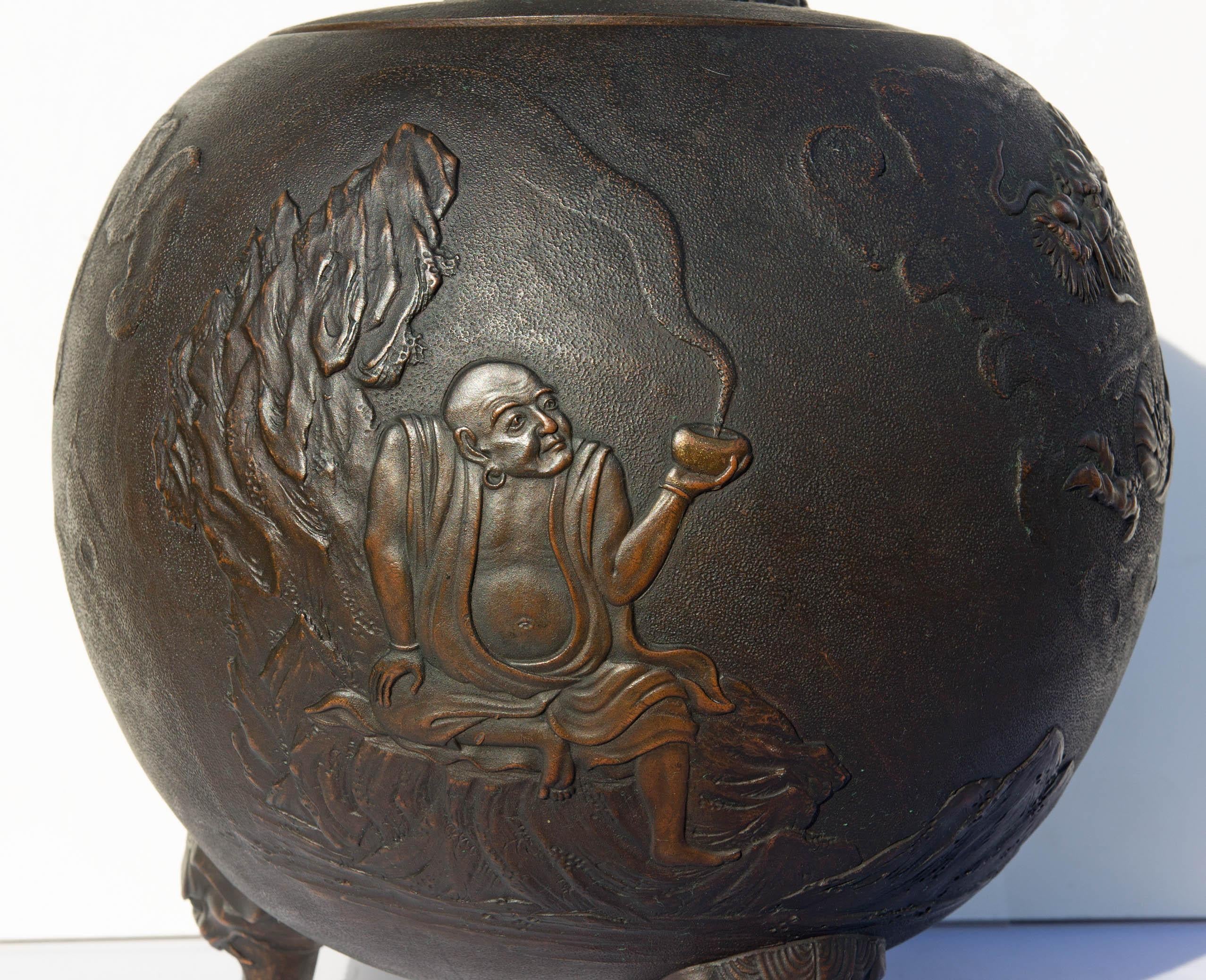 Antique Japanese covered jar. Scenic decoration with a scholar, dragon and foo dog. Bronze clad ceramic. Rich patina. Meiji period, circa 1900-1920.