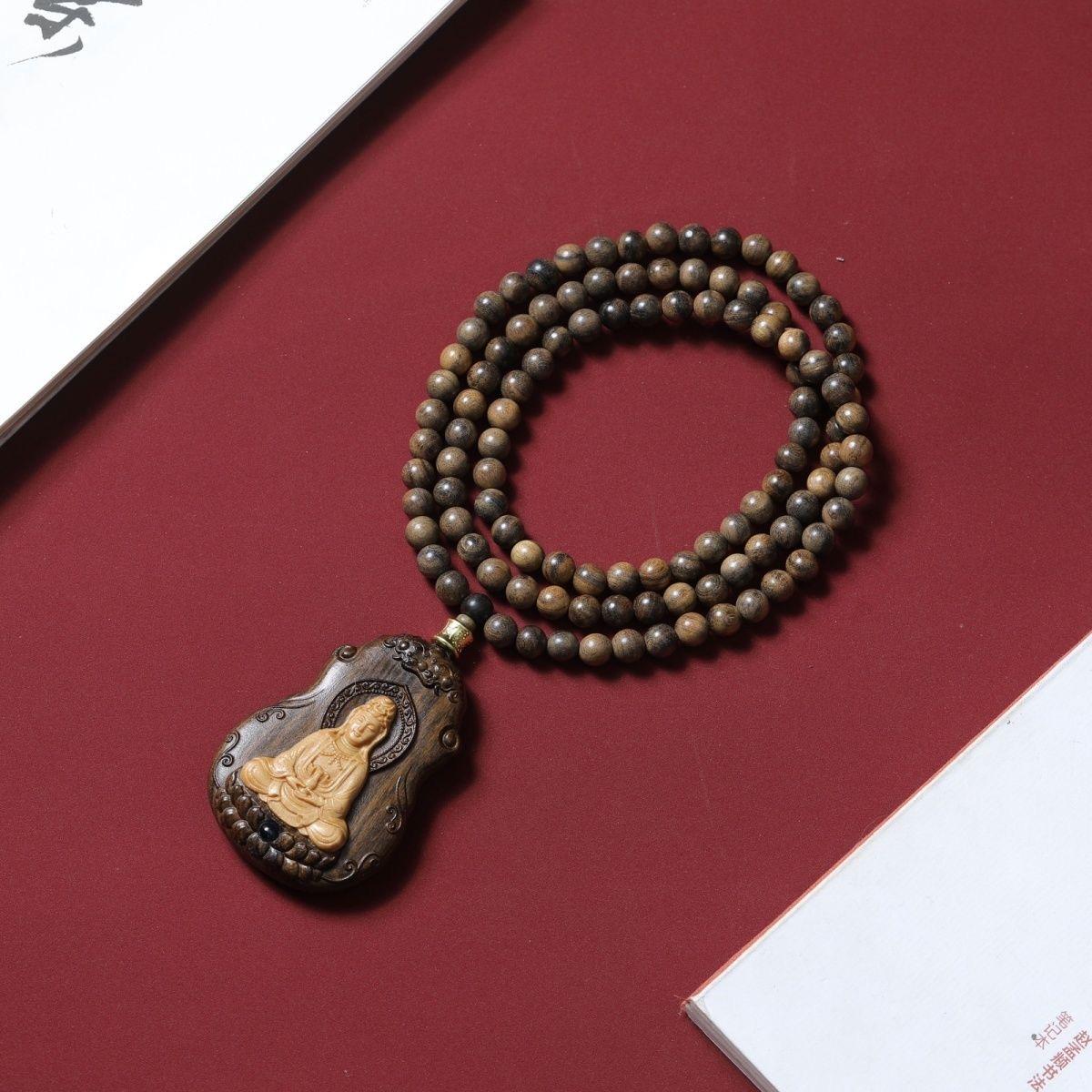 This Asian agarwood engraving of a Guanyin Buddha pendant necklace is a highly valued piece of art and spirituality. Guanyin, also known as Guan Yin or Kwan Yin, is a beloved bodhisattva in East Asian Buddhism, symbolizing compassion and mercy. When