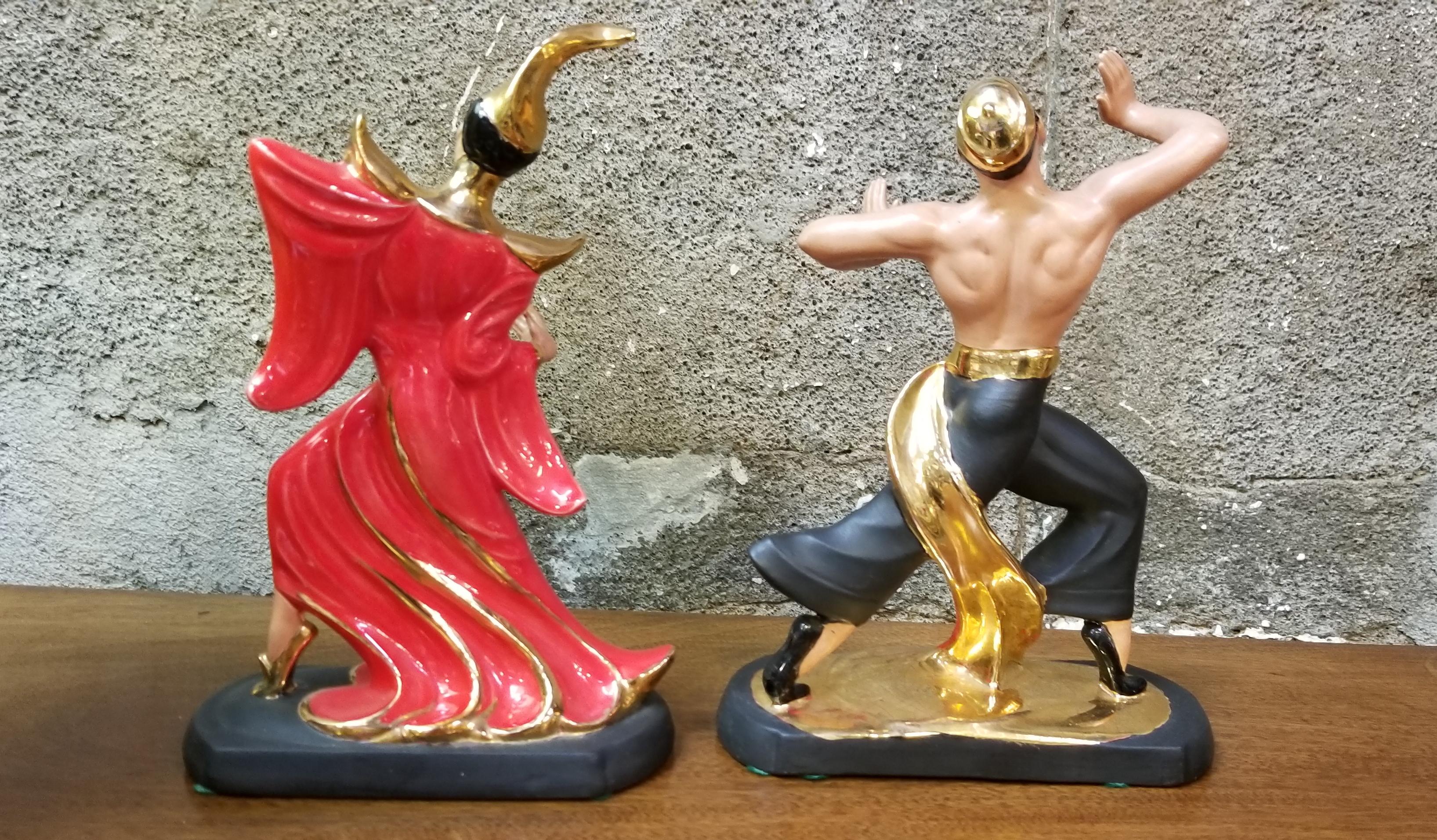 A 1950s pair of ceramic oriental dancing figures in the manner of Hedi Schoop. Classic 1950s decor with primary colors of red, black and gold. Excellent original condition. Unknown maker.

Dimensions are for each figure.