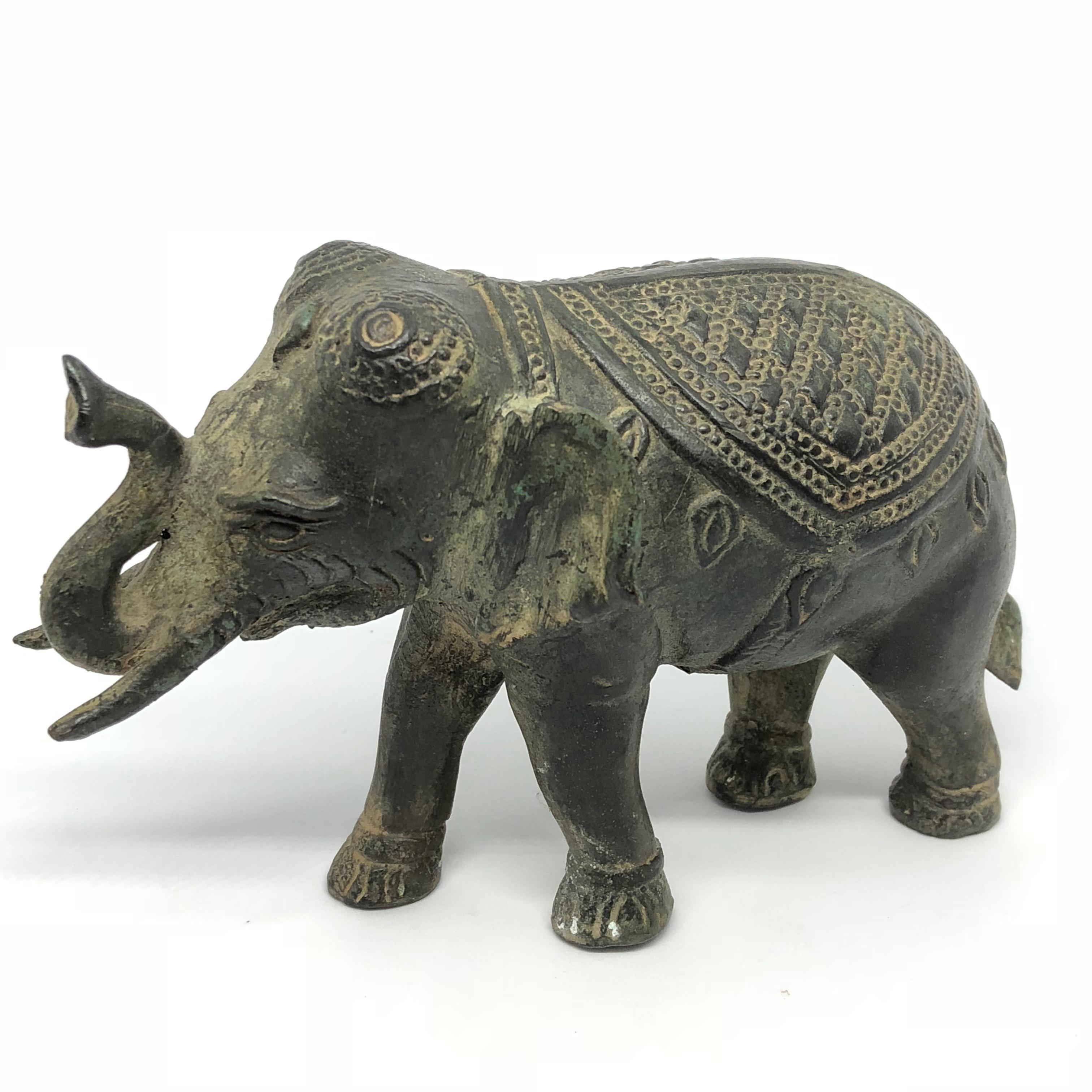 A decorative hand made elephant sculpture or statue. Some wear but this is old-age. Made of brass or bronze. We think it is from Asia and was made in the mid-20th century.