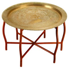 Table asiatique à plateau en laiton gravé et martelé avec base pliable en bois, vers les années 1960