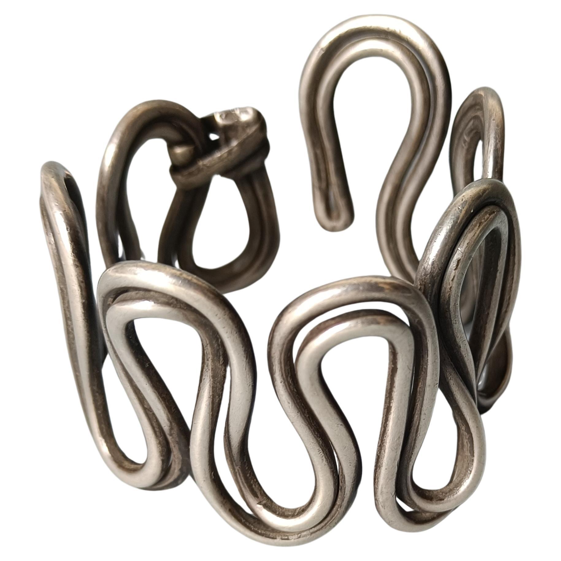 Un lourd bracelet tribal indien ancien du Rajasthan fait de fils d'argent torsadés en forme de zigzag d'une simplicité frappante mais très stylisée.

Il est traditionnellement porté sur la partie supérieure du bras. 

Ce qui est bien avec ce